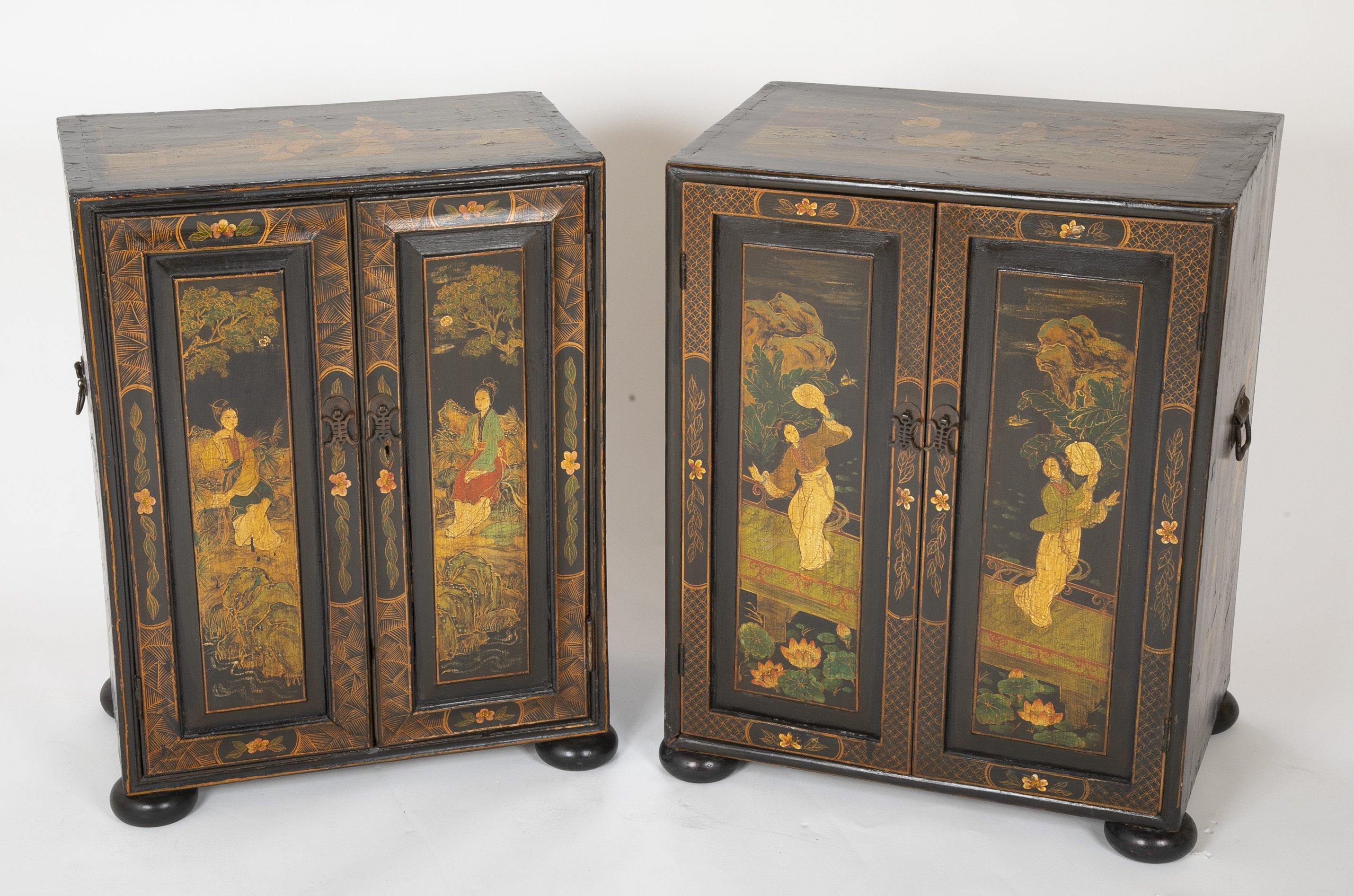 A near pair of Chinese Export chinoiserie decorated two-door low cabinets with interior shelves and drawers on bun feet.
 