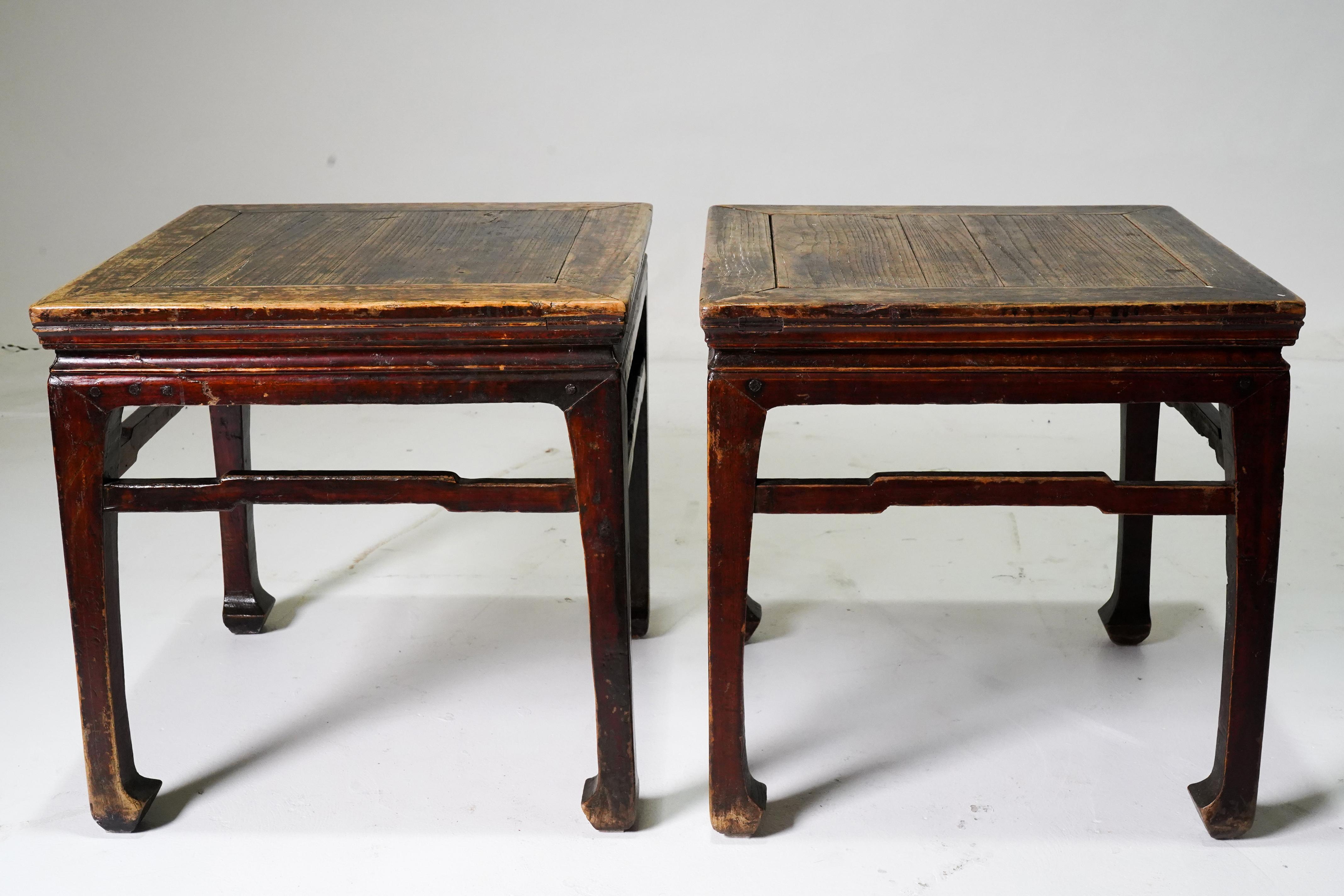A pair of Chinese Ming Dynasty style stools (or side tables) from the mid-19th century, with humpbacked stretchers, horsehoof feet and waisted aprons. The stools (sometimes called thinking stools) feature a square top with central board, sitting