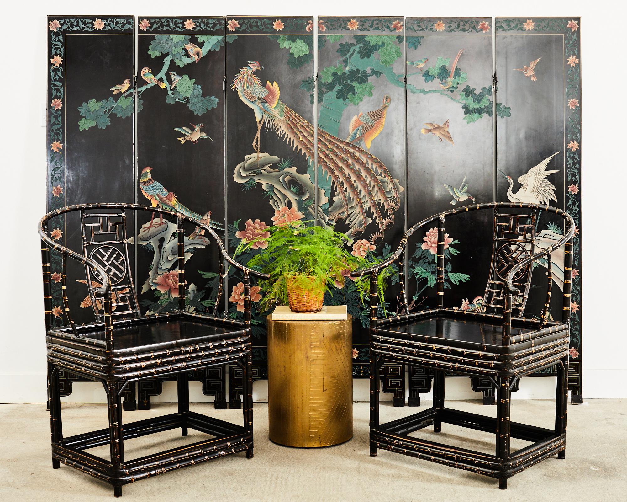 Dramatic pair of 20th century Chinese export bamboo chairs featuring a gracefully curved horseshoe back ending with out swept hooks. Constructed in the Ming dynasty style with a decorative geometric open fretwork design splat. The generous square