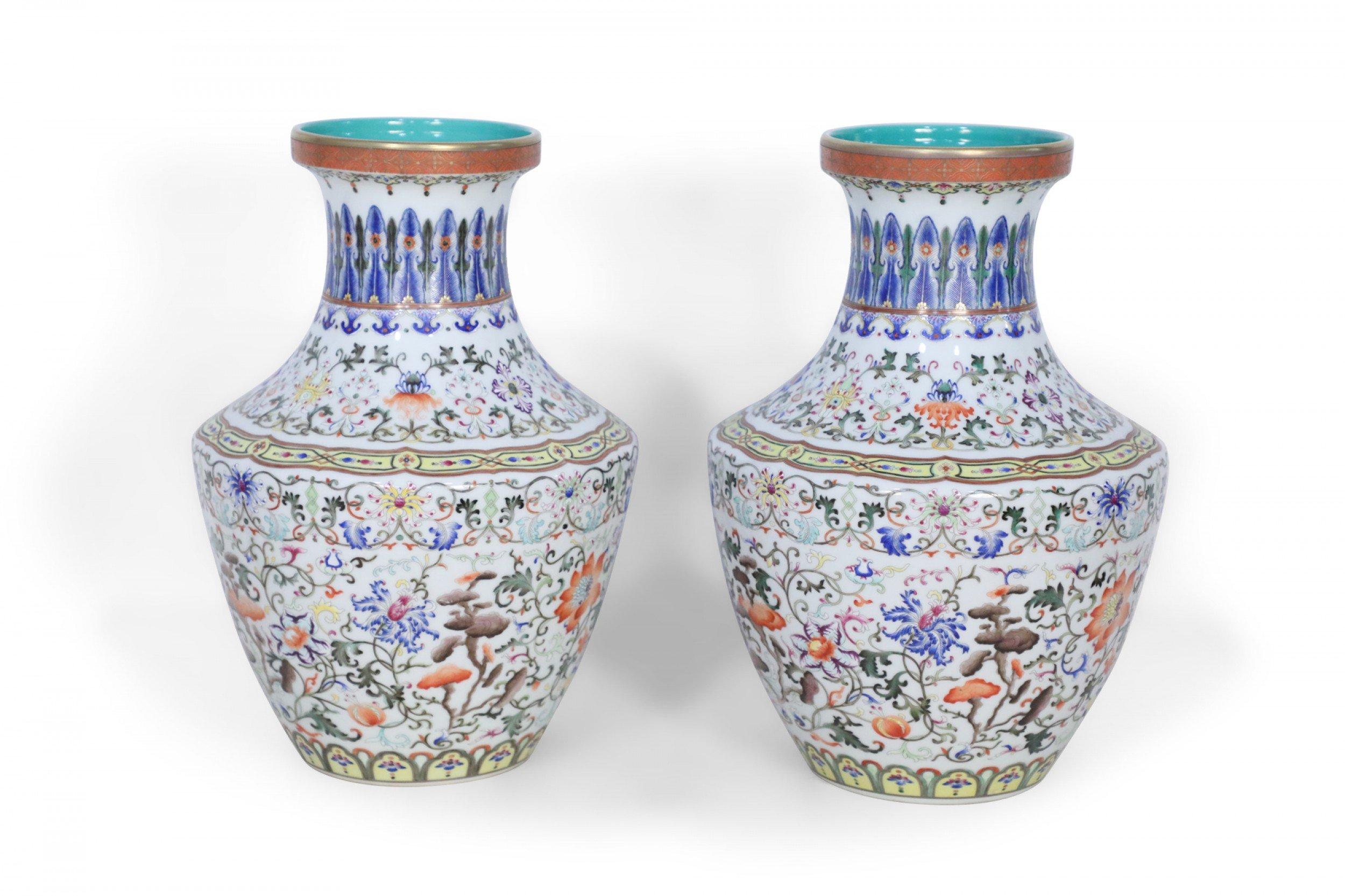 Pair of Chinese vases decorated with all-over swirling floral motifs intercepted by yellow patterned bands at the bottom and top of the base and striking blue designs wrapping concaved necks, and turquoise blue interiors (priced as pair).
    