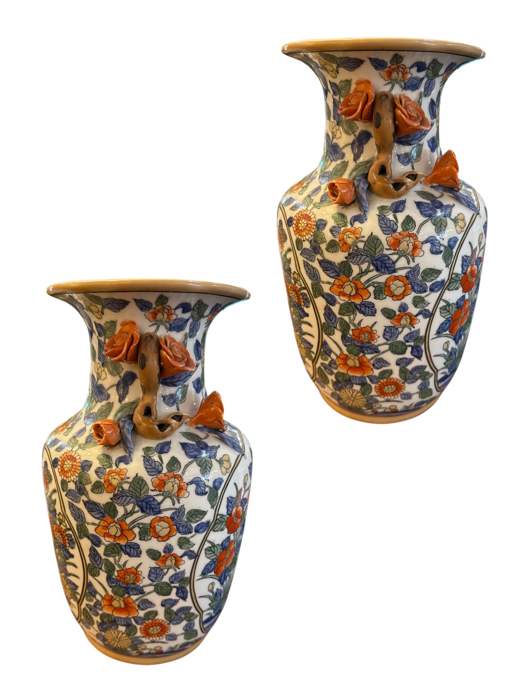 Dieses exquisite Paar chinesisch-orientalischer Porzellanvasen verbindet auf wunderbare Weise traditionelle Kunstfertigkeit mit aufwändiger Handwerkskunst. Jede Vase zeigt ein reiches, handgemaltes Design aus lebhaften Blumen, anmutigen Vögeln und