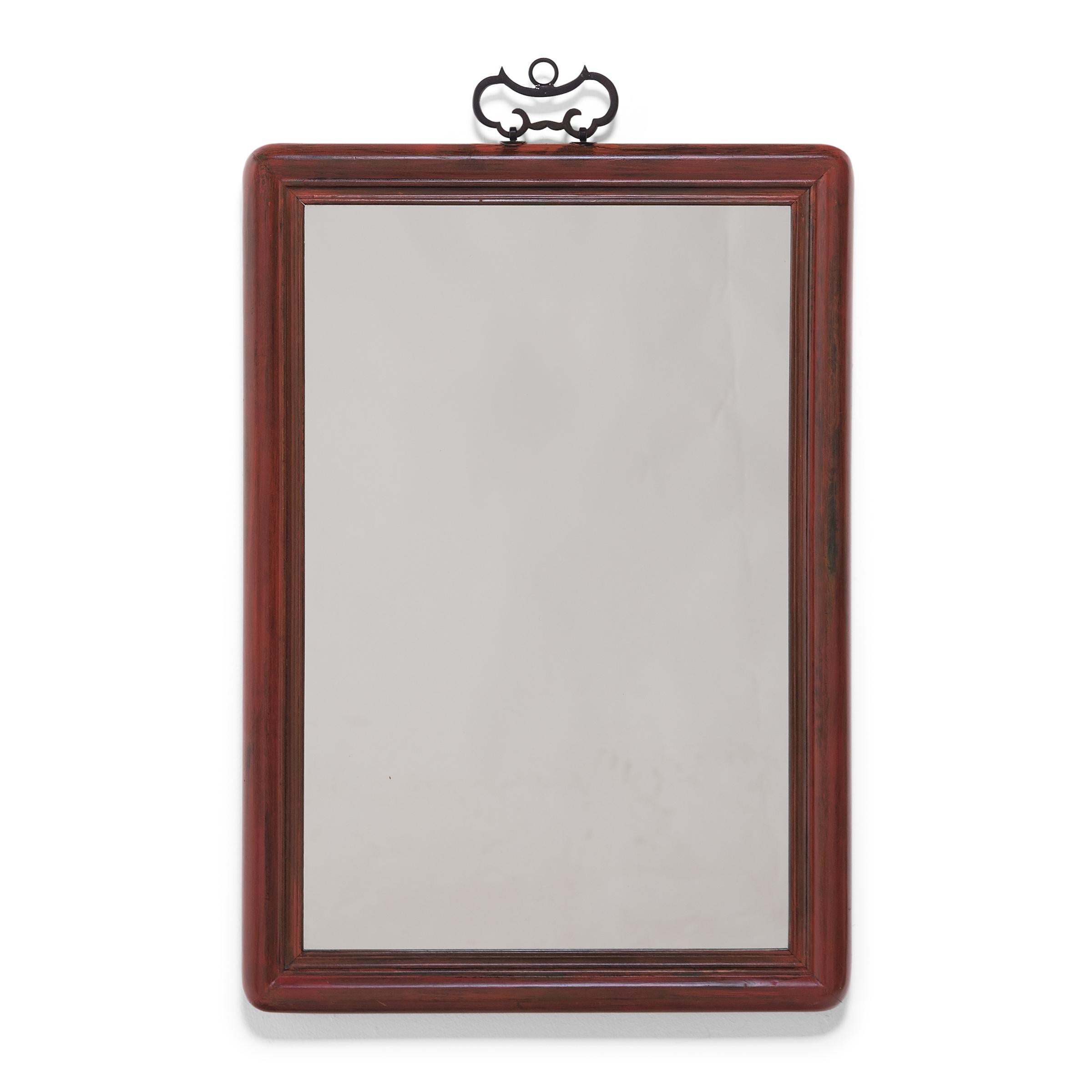 This pair of rectangular wall mirrors feature early 20th-century frames crafted of a fine-grained hardwood. At some point in their storied history, the frames were brushed with red paint, now gently worn to reveal the wood grain underneath. The