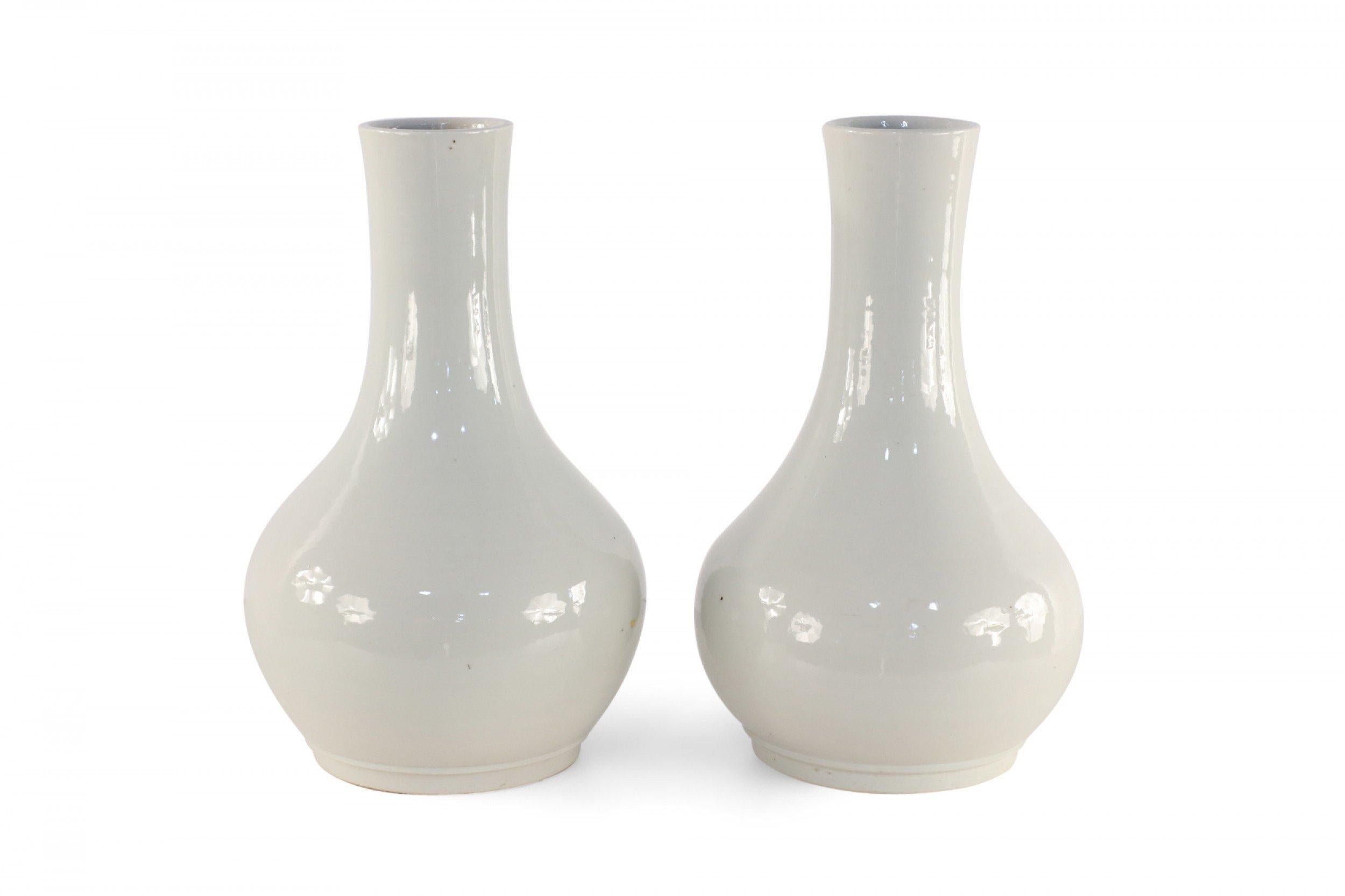 Paire de vases similaires en porcelaine chinoise aux formes globulaires dans des teintes gris pâle avec des finitions émaillées (les vases varient légèrement en forme) (PRIX DE LA PAIRE).
 