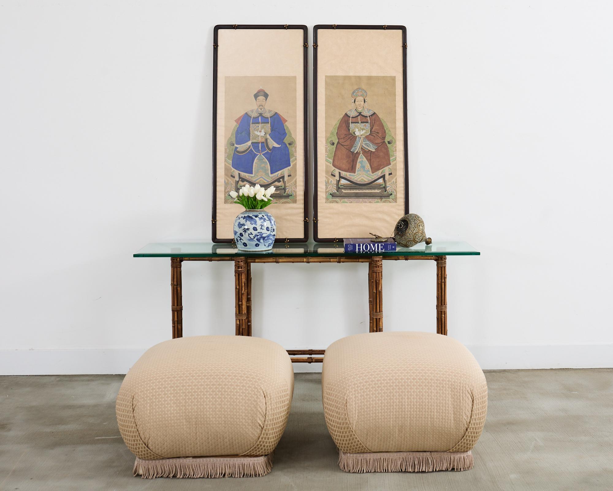 Stately pair of Chinese export ancestor portraits depicting a patriarch and matriarch of high ranking official status. Both depicted sitting and wearing decorated robes and hats. Mounted in wood frames with plexiglass and silk brocade borders. Price