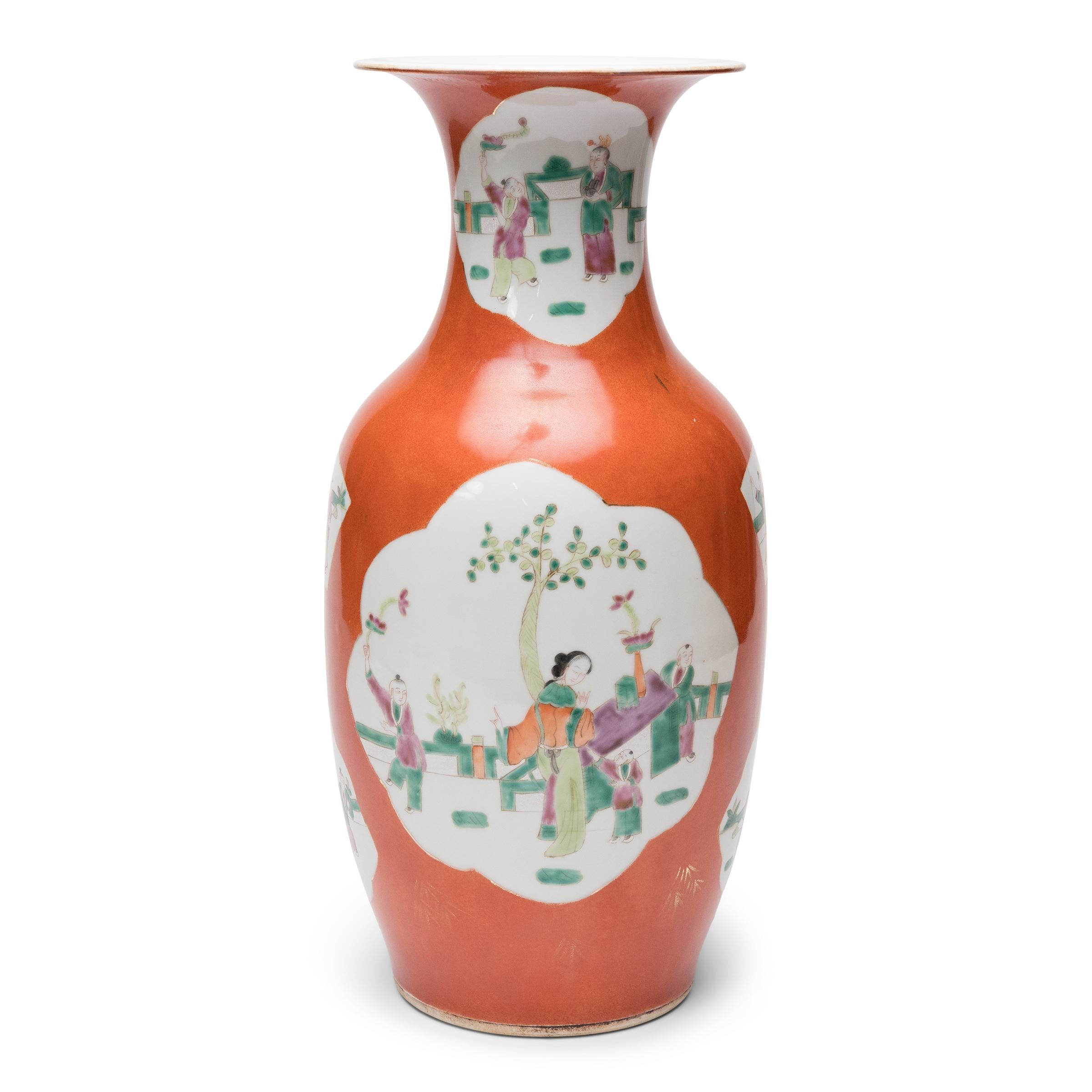 This early 20th century porcelain vase is sculpted to a classic Chinese phoenix-tail form and decorated with persimmon-orange enamel and several cartouche paintings of picturesque scenes. Hand-painted with pastel enamels in the famille rose manner,