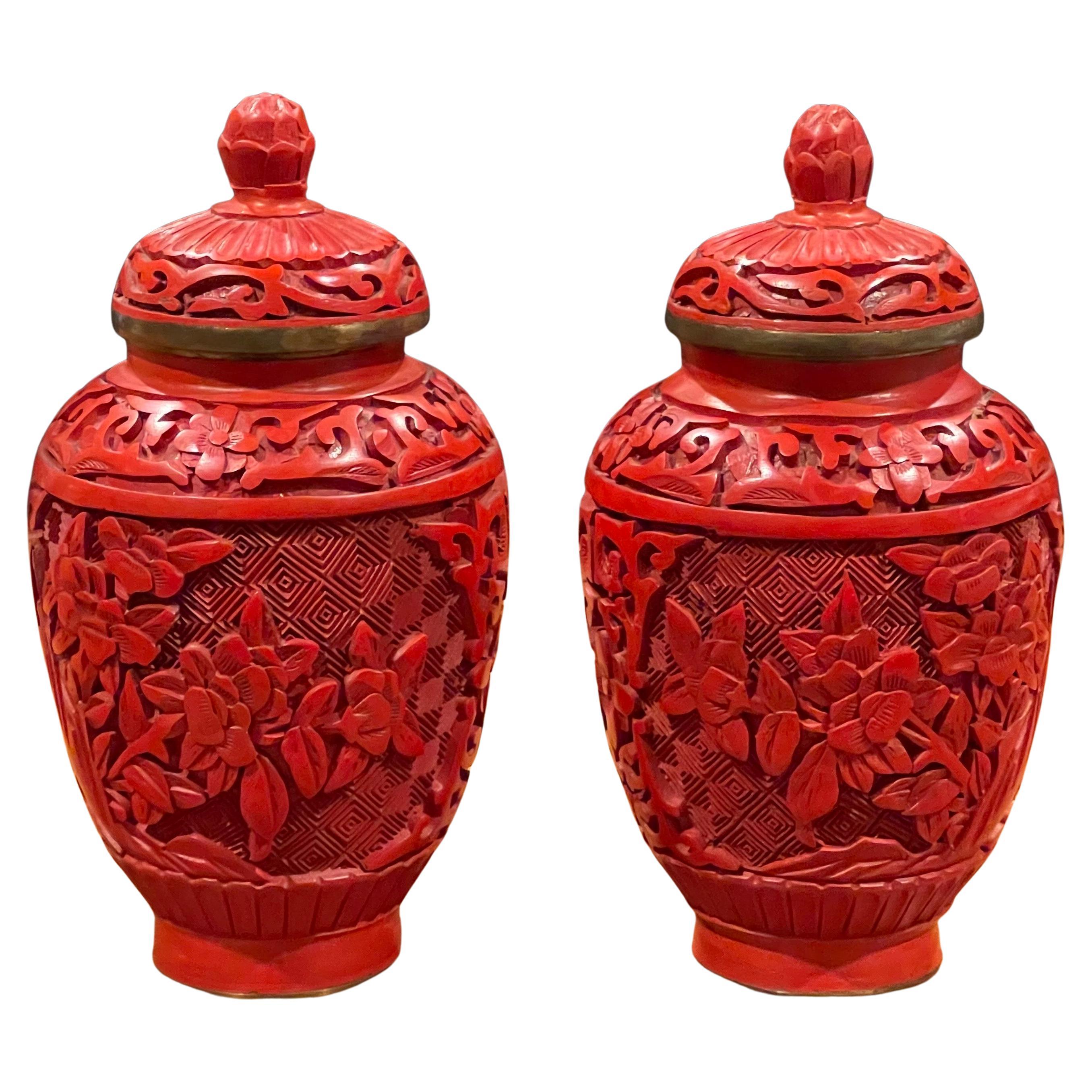 A very well crafted pair of Chinese mirror image cinnabar lacquered petite temple jars, circa 1970's. The vases are 5.25
