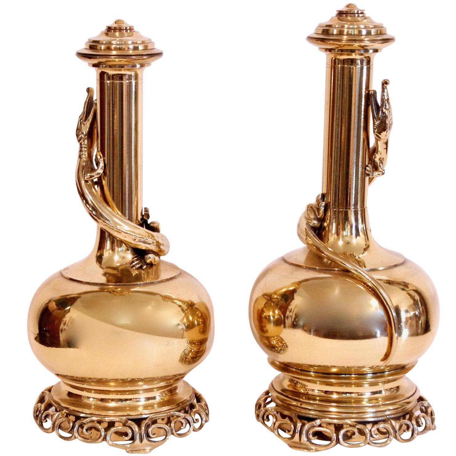 A striking and decorative pair of handsome brass bottle flasks, originally oil lamps,  fitted with intricate openwork fretwork bases. An alligator like lizard is wrapped around each. There is a screw cap at the top of each opening to a reservoir