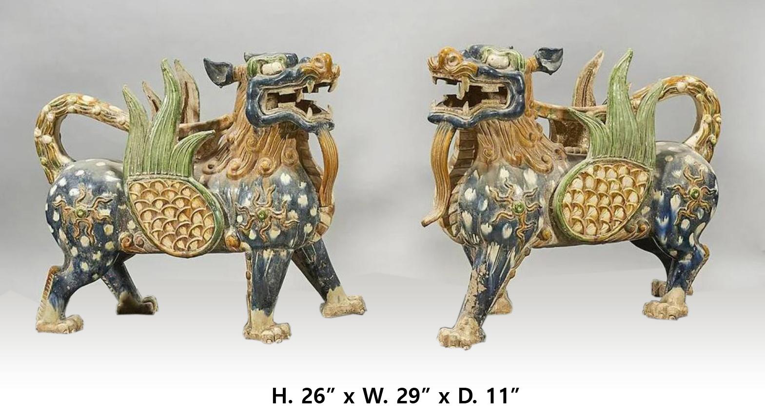 Attractive large Chinese pair of hand painted glazed pottery winged Fu-dogs in walking position. 
The Fu-dogs can be used indoors or outdoors, they are beautifully proportioned. 20th century
Measures: H. 26