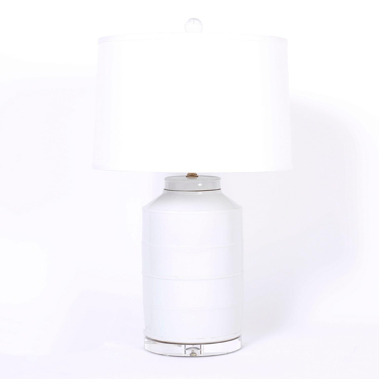 Pair of Chinese porcelain table lamps with a classic form and an off white celadon finish with four subtle rings around the diameter. Presented on lucite bases.