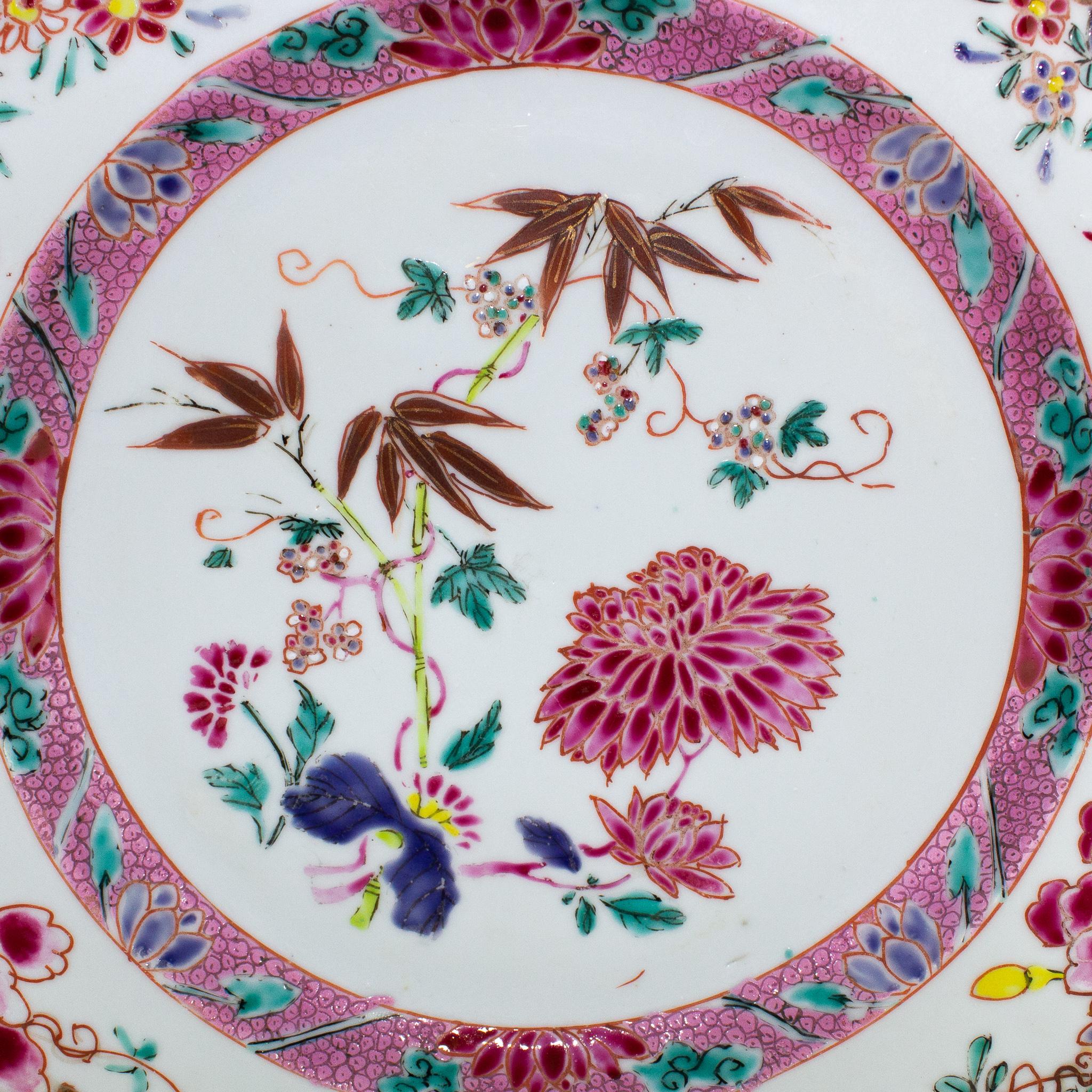 Pair of Chinese porcelain rounded dishes, East India Company, Yongzheng period (1723-1735). Polychrome decoration depicting in the centre bamboos, emblem of longevity, and floral motifs. The centre it’s framed by a frieze of overlapping scale