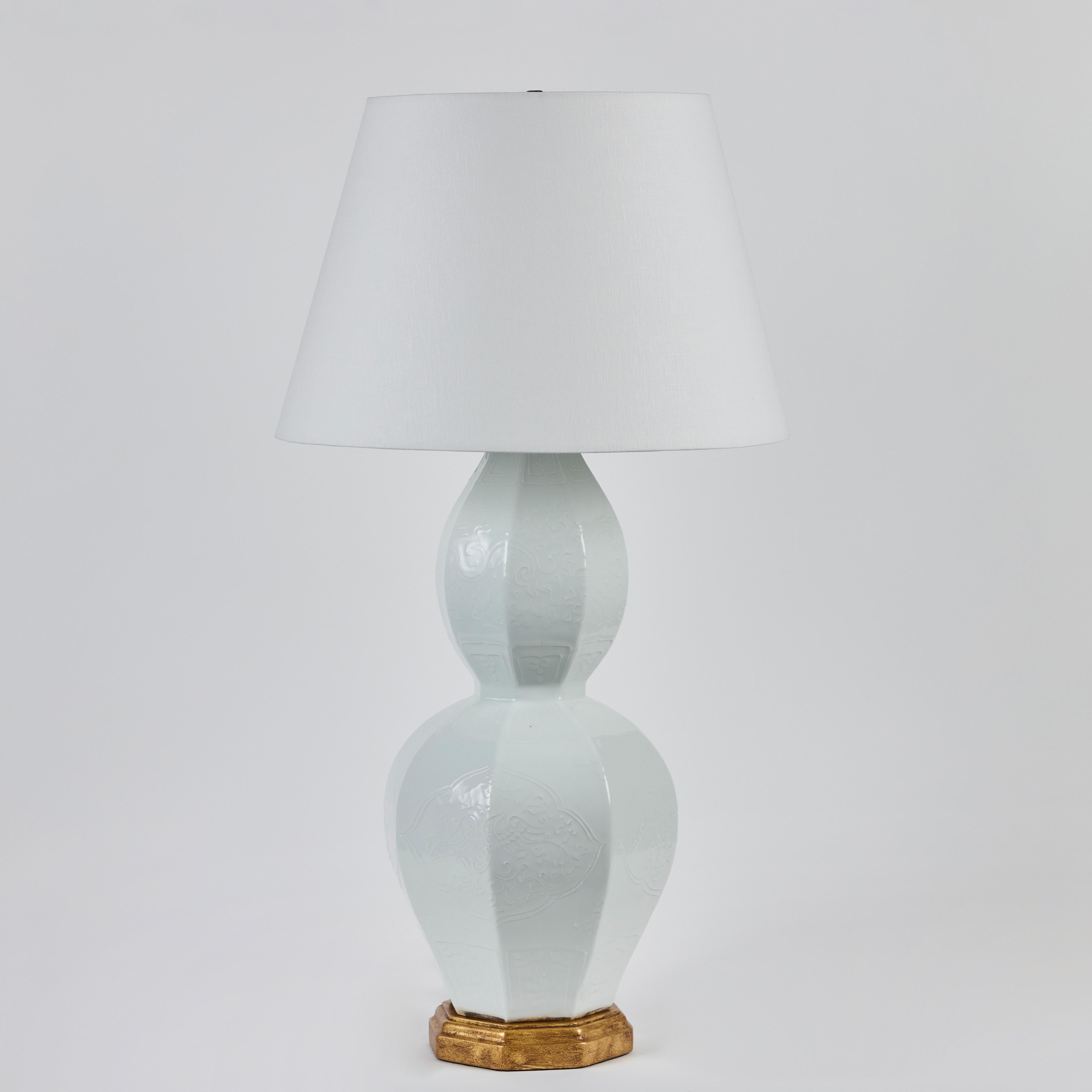 Paire de vases en porcelaine chinoise du 20e siècle, en forme de double gourde, utilisés comme lampes sur des montures en bois doré.  Teintes de lin.  L'abat-jour a un diamètre de 18