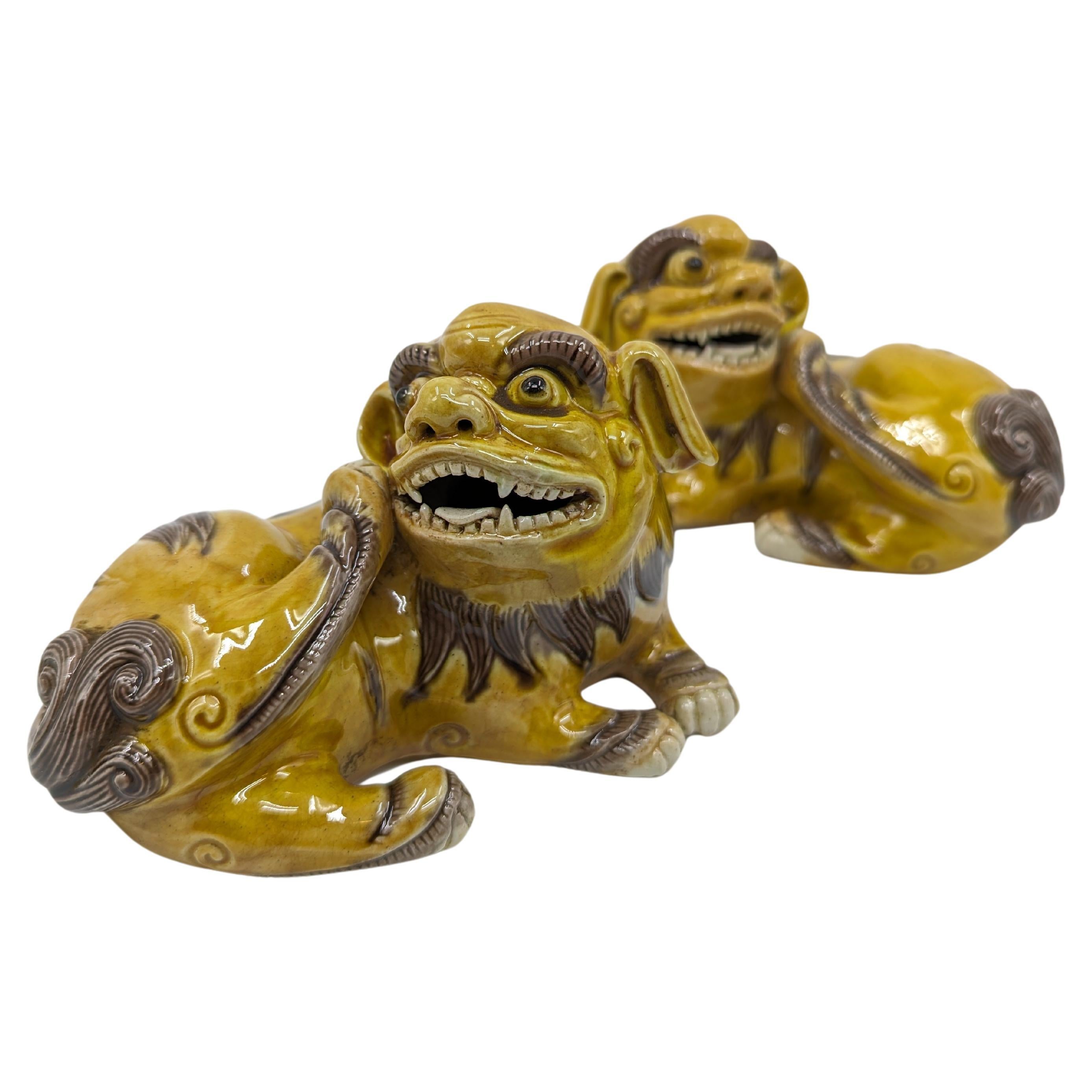 Behold a vibrant pair of Chinese Famille Jaune Foo Dogs, a magnificent representation of Chinese artistry and symbolism. These exquisite figures, crafted with meticulous attention to detail, capture the dynamic essence of Foo Dogs, also known as