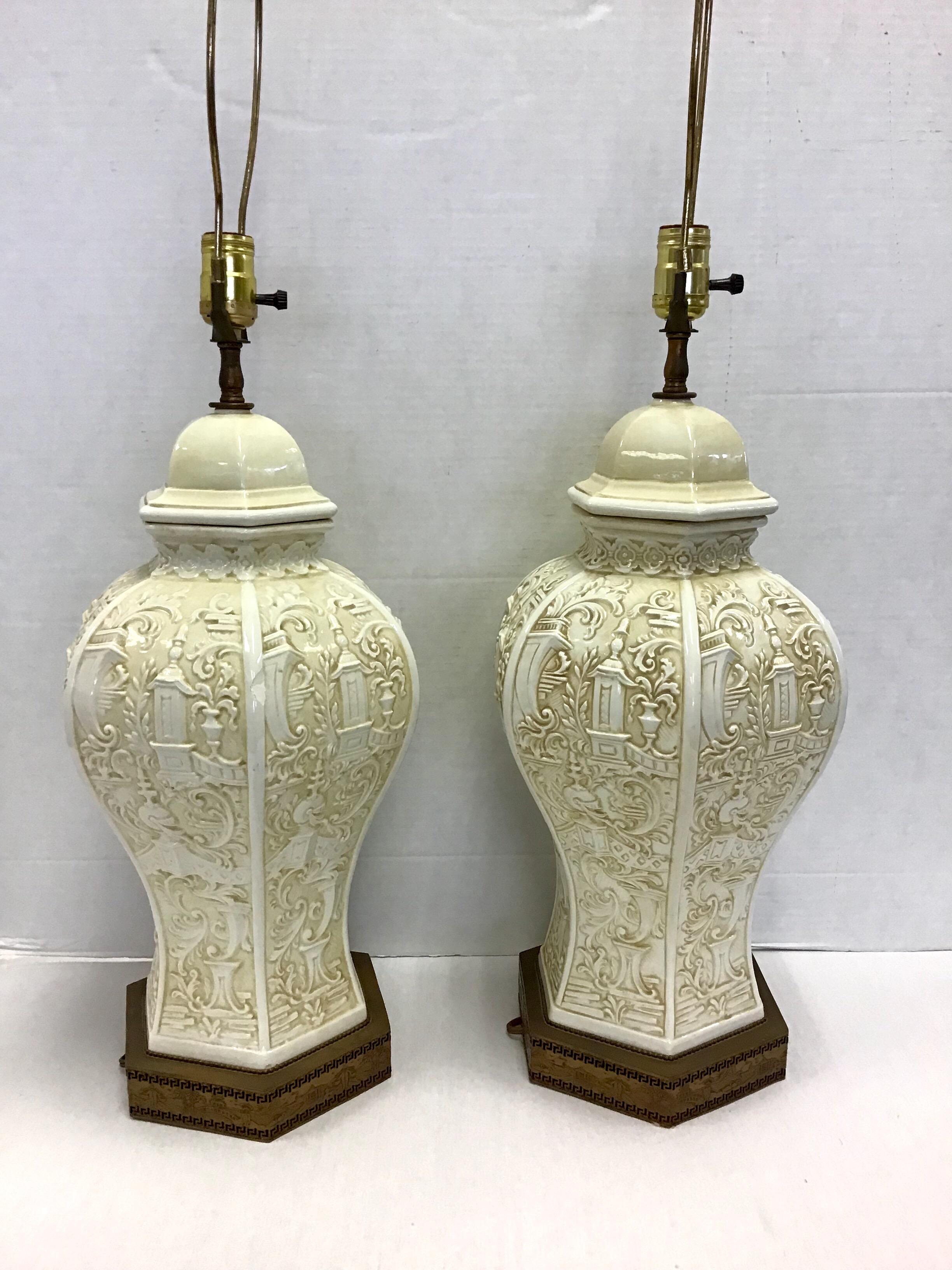 Lovely vintage midcentury pair of Chinese porcelain ginger jar lamps in the palest yellow color. Feature a raised porcelain design of pagodas throughout and a pierced brass base with a relief of a Chinese landscape.
Condition is excellent except for