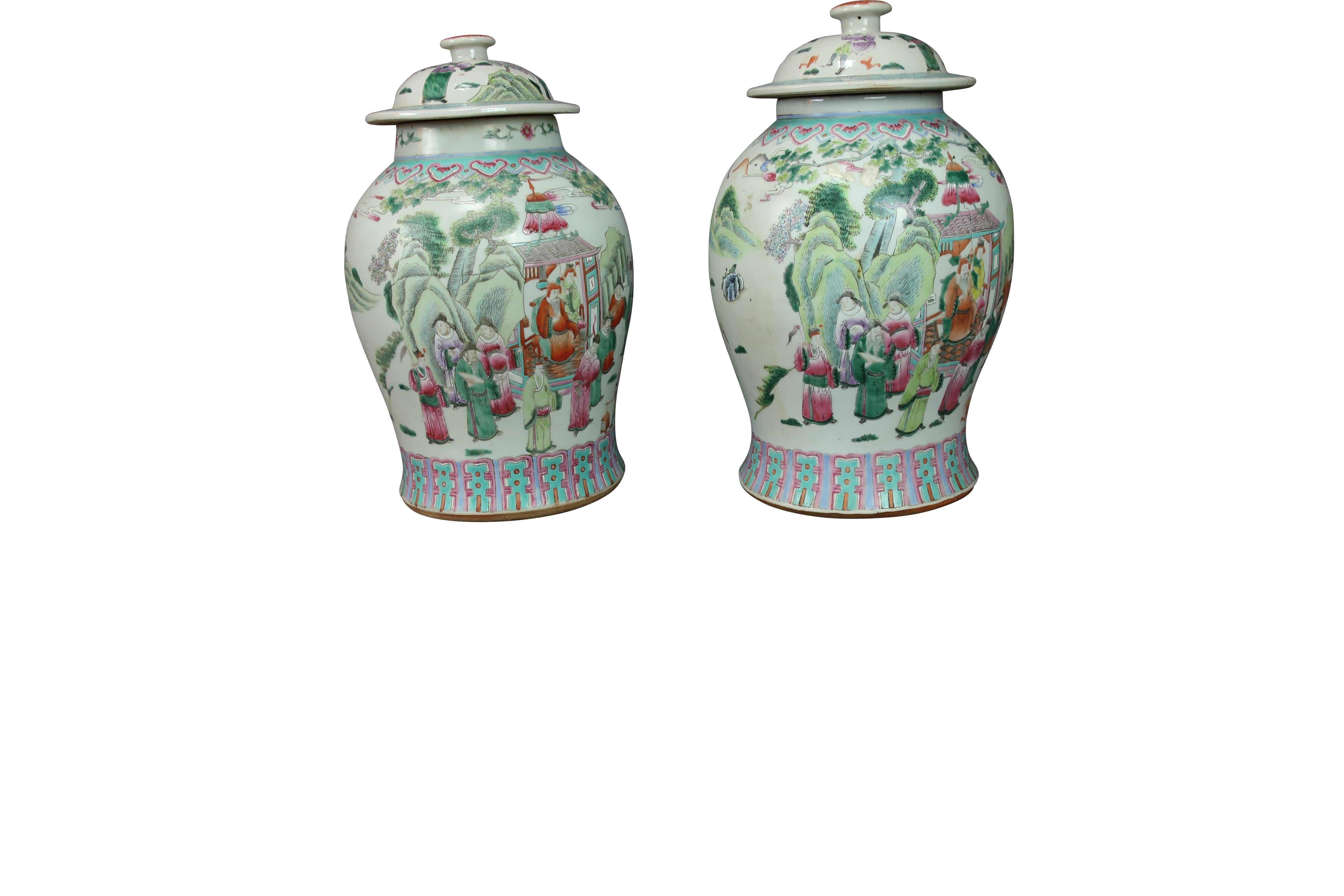 Pair of Chinese Porcelain ginger jars with covers, blue, green coral and, pink coloration decorated with a Chinese village landscape design.