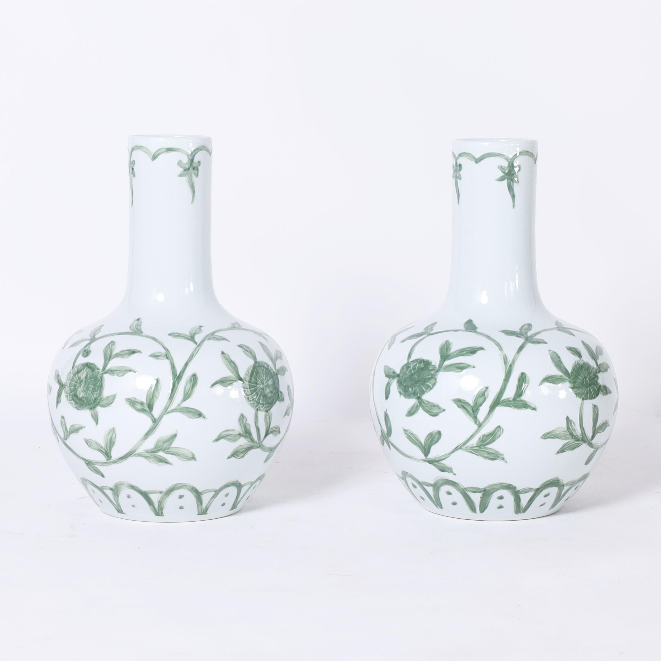 Delightful pair of Chinese porcelain vases with classic form and hand decorated in green and white floral designs. 