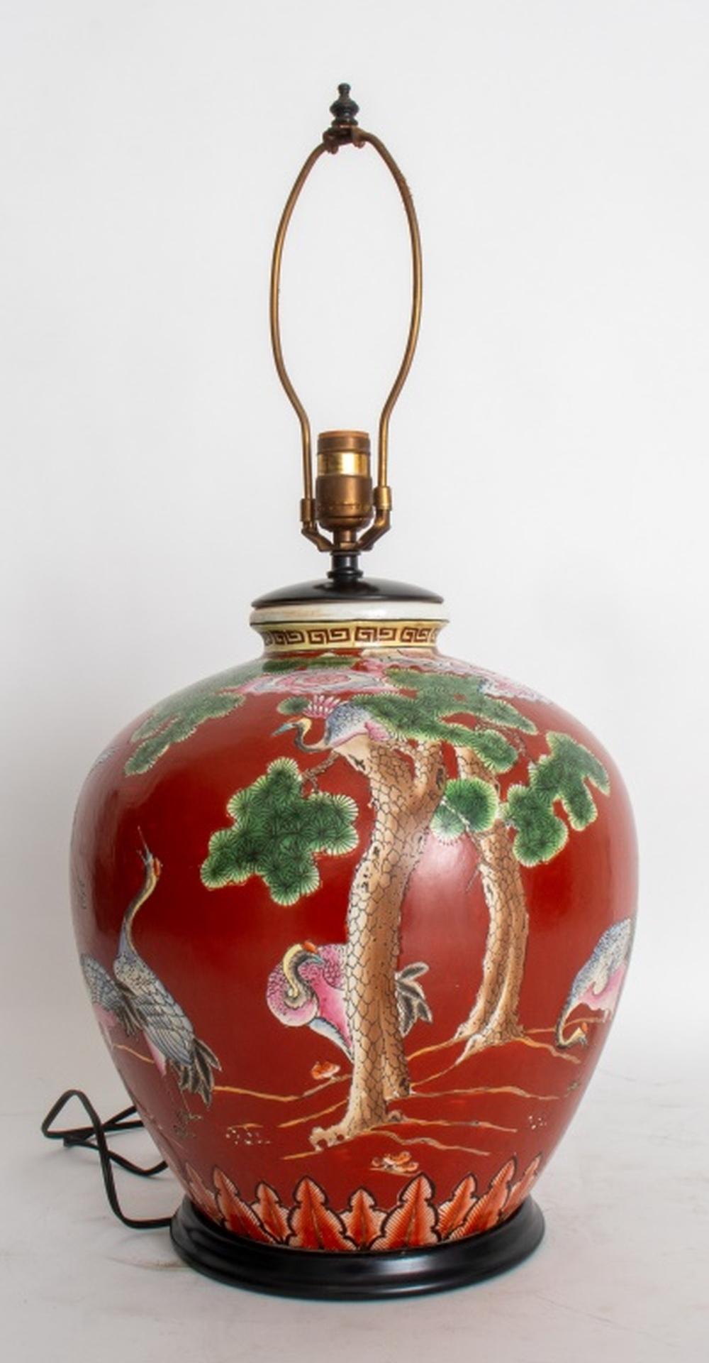 Pair of Chinese Porcelain Ovoid Vases Mounted as Lamps, featuring intricate painted designs of pine trees and herons. The vases have a rich red background that highlights the detailed artwork and adds warmth to any space.

Each lamp measures 27