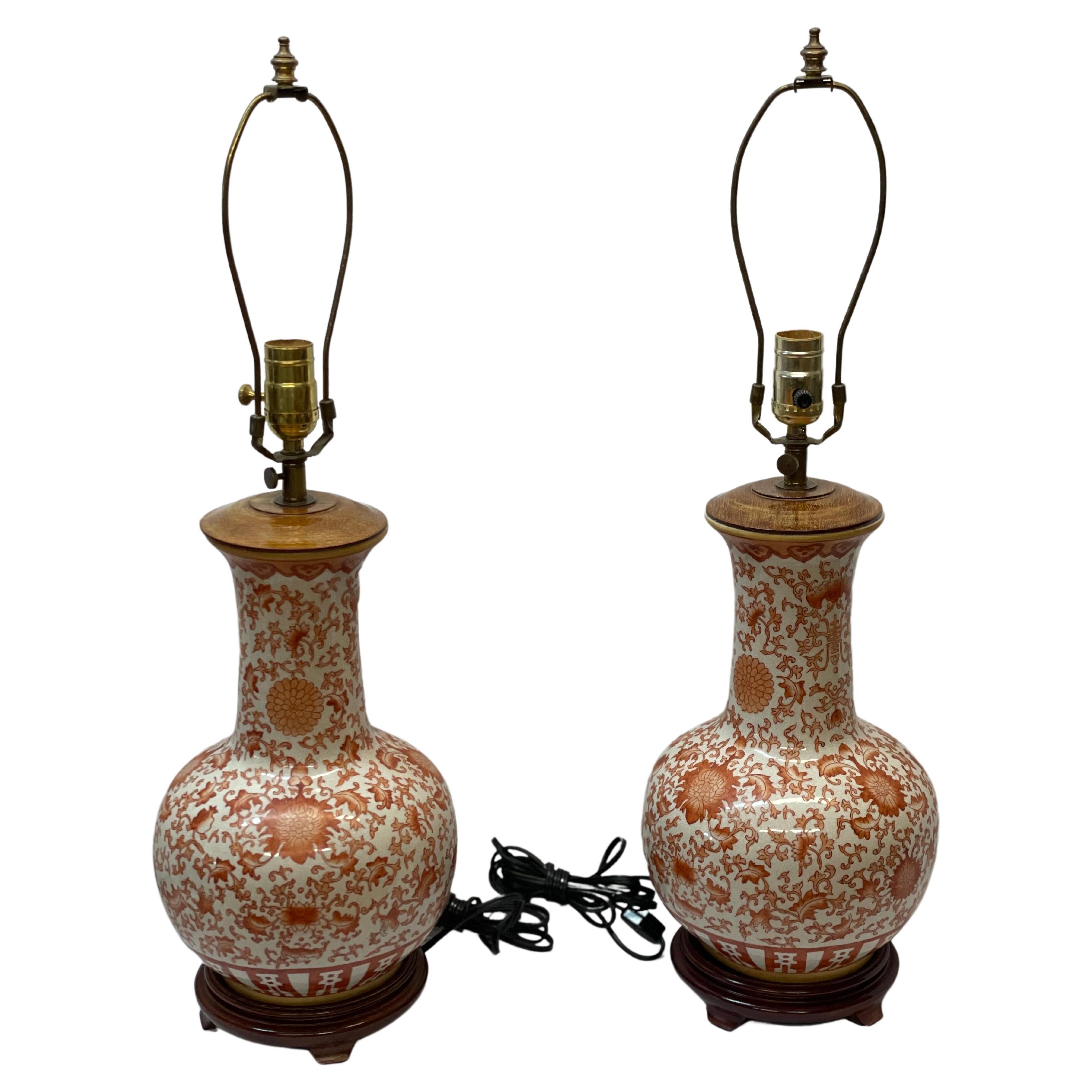 Pair of Chinese porcelain table lamps with painted Lotus design on wood stands For Sale