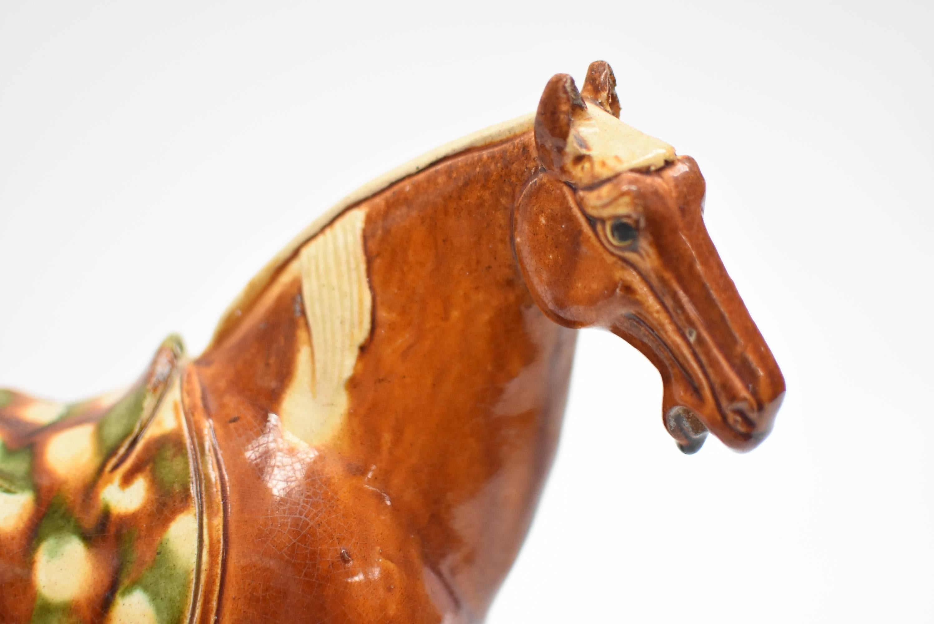 This pair of beautiful terracotta horses are handmade and painted using the ancient tri-glaze techniques. A true work of art, the splendid glossy glaze is distinctive of Tang San Cai style. Glaze is skillfully applied achieving high artistic effect.