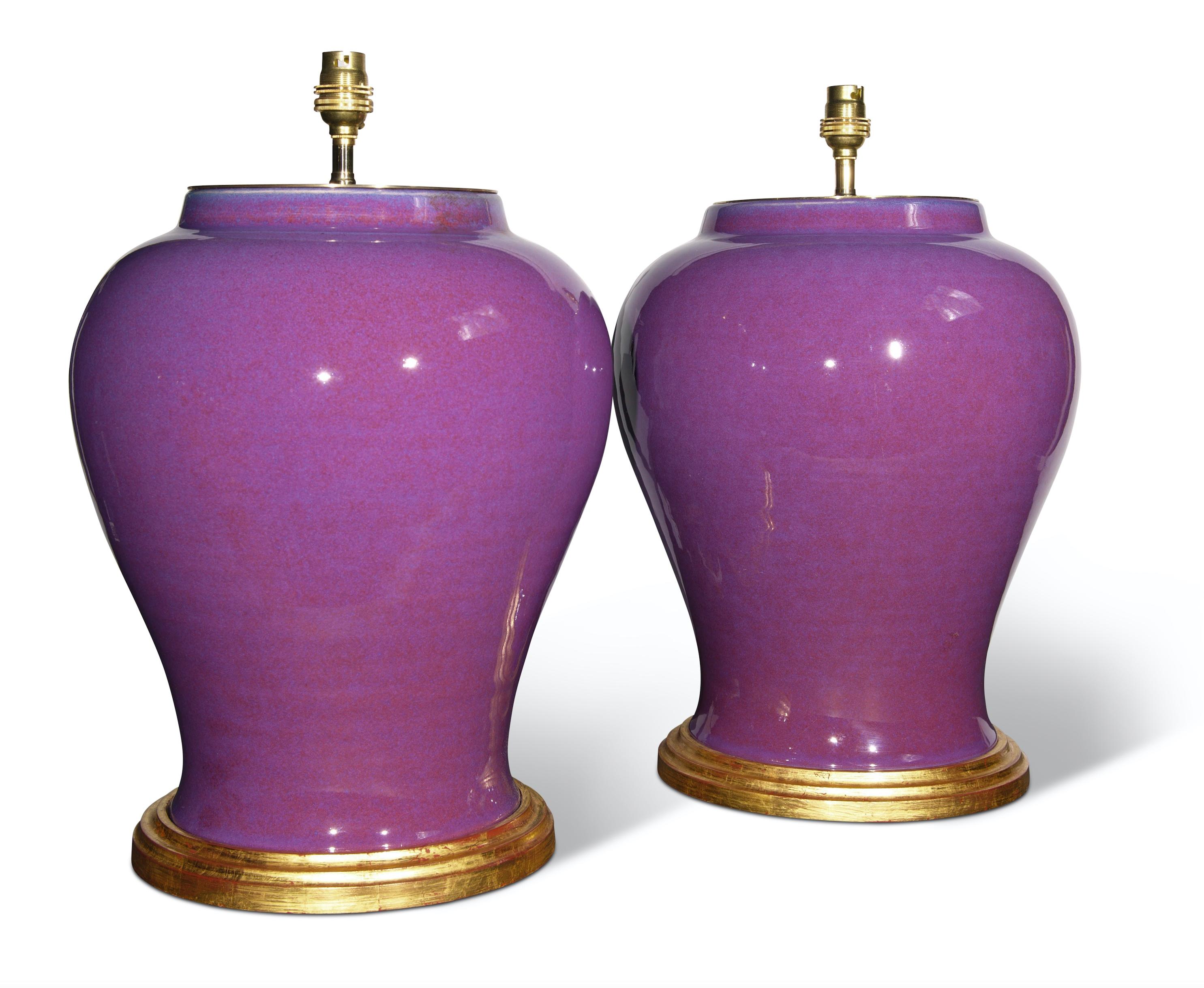 A superb pair of Mid-20th Century French porcelain vases, with a wonderful plum purple glaze, now mounted as lamps with hand gilded turned bases.

Height of vases: 14 1/2 in (37 cm) including giltwood bases, excluding electrical fitments and
