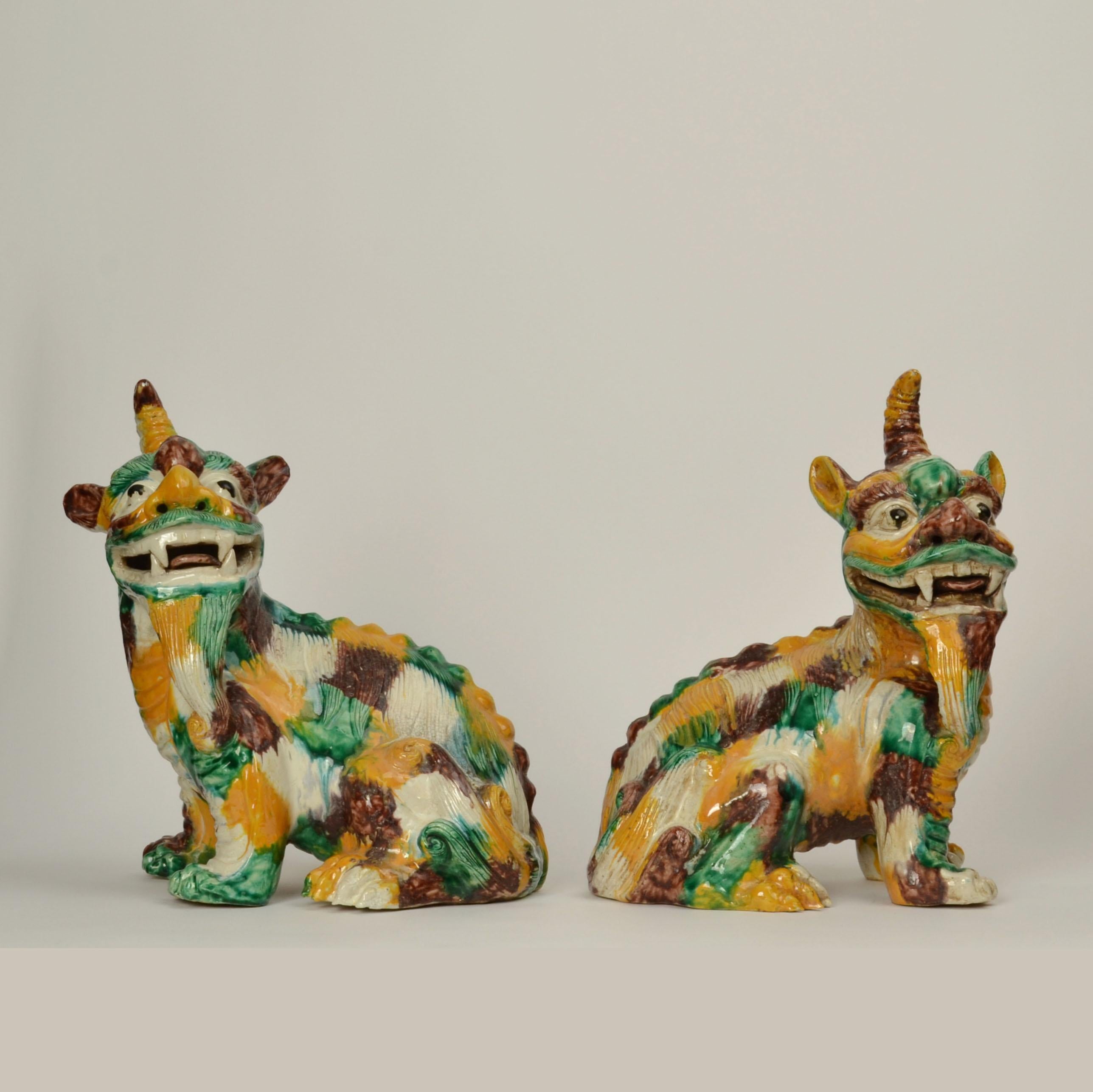 Pair of Qilin 20th century Chinese figures, sancai glazed ceramic. Sancai is a vibrant Chinese slip glaze in predominantly three colours aubergine, amber, green, and white. 
The Qilin is said to have an equine-like body. Thus, the Qilin may have the
