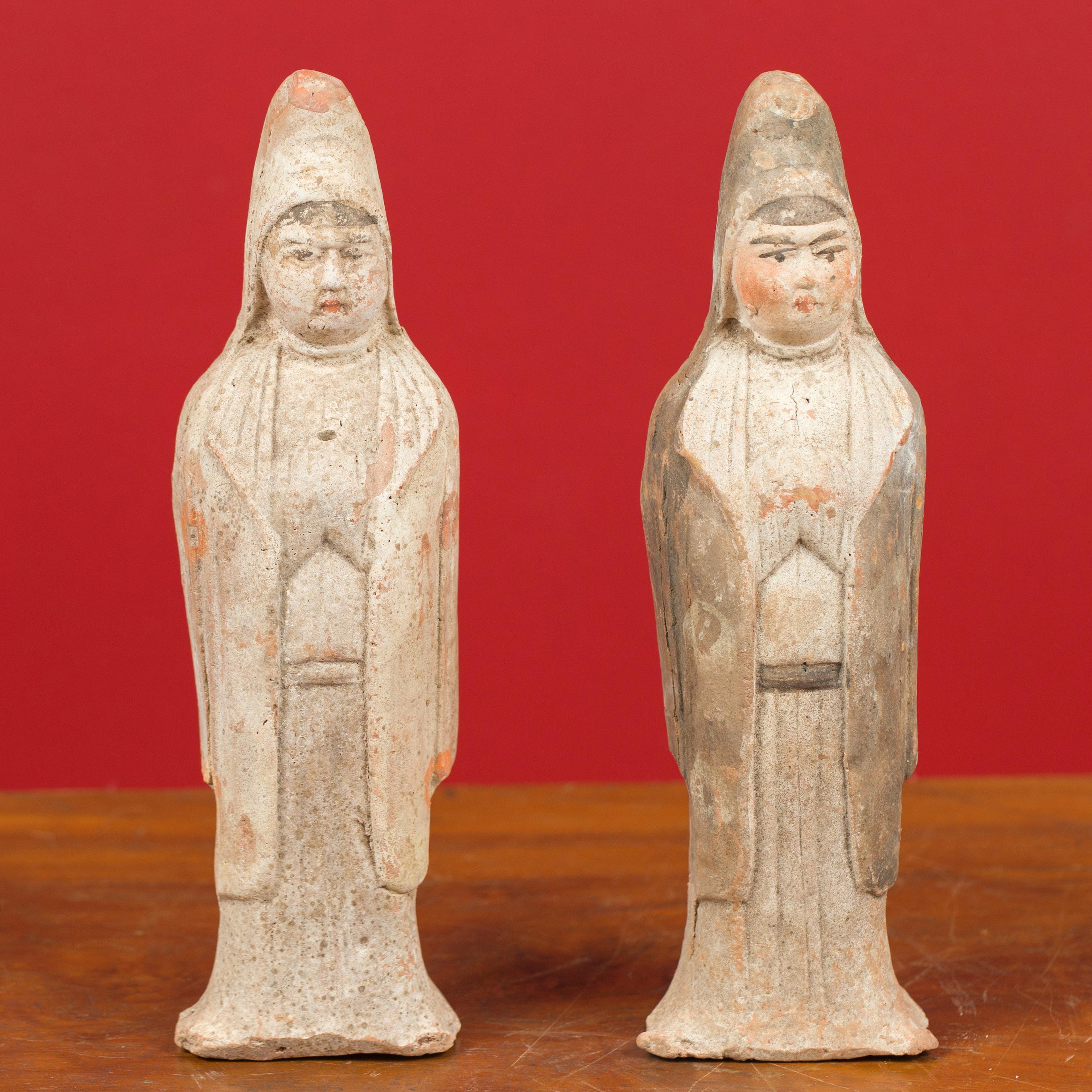 A pair of Qing dynasty 20th century terracotta Chinese hooded priestess sculptures with original paint. Discover the exquisite charm of this pair of 20th century Qing dynasty terracotta Chinese hooded priestess sculptures. These small, hollow