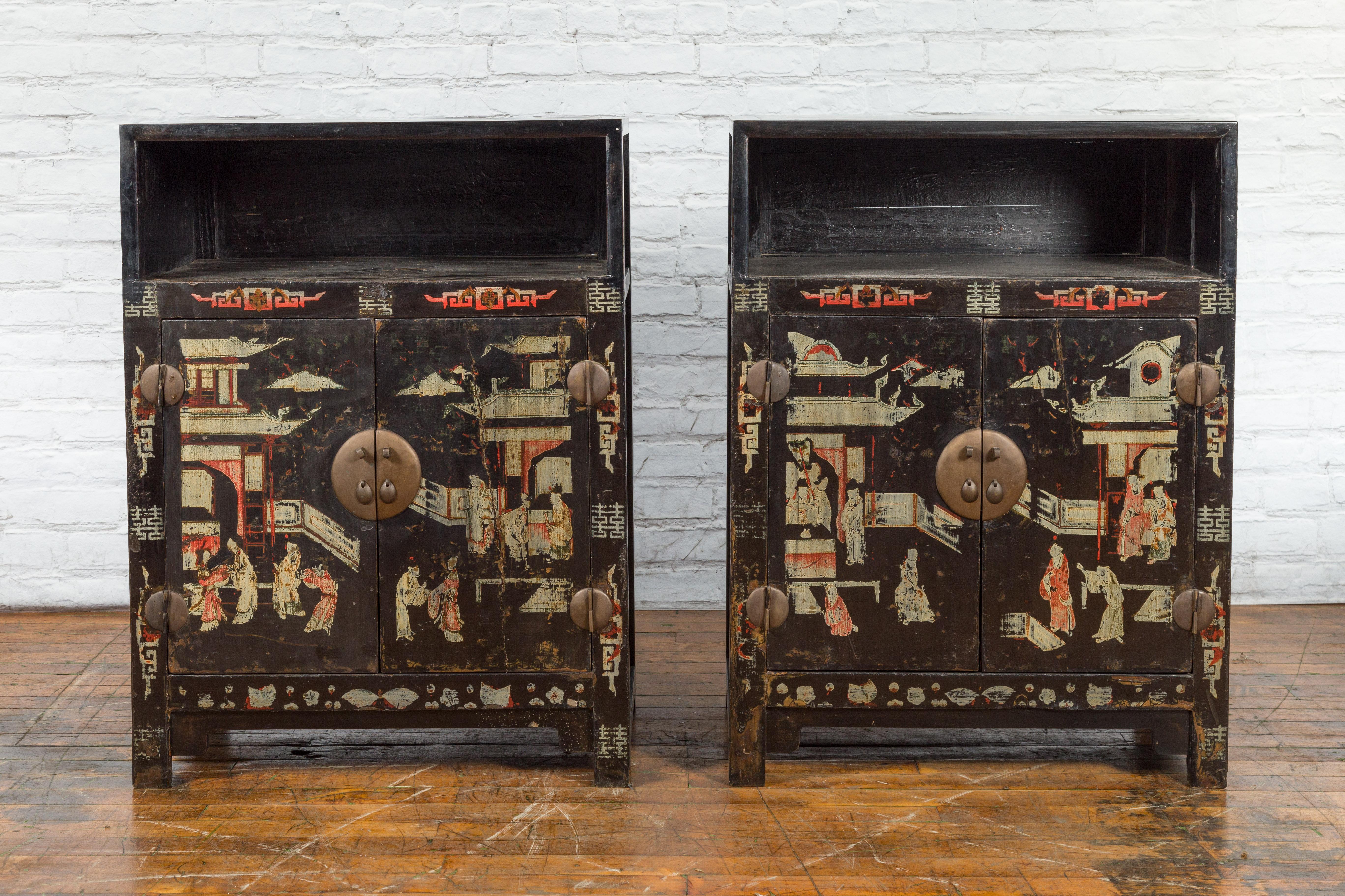 A pair of Chinese Qing Dynasty period black lacquer display cabinets from the 19th century, with hand-painted décor depicting court scenes. Created in China during the Qing Dynasty period in the 19th century, each of this pair of display cabinets
