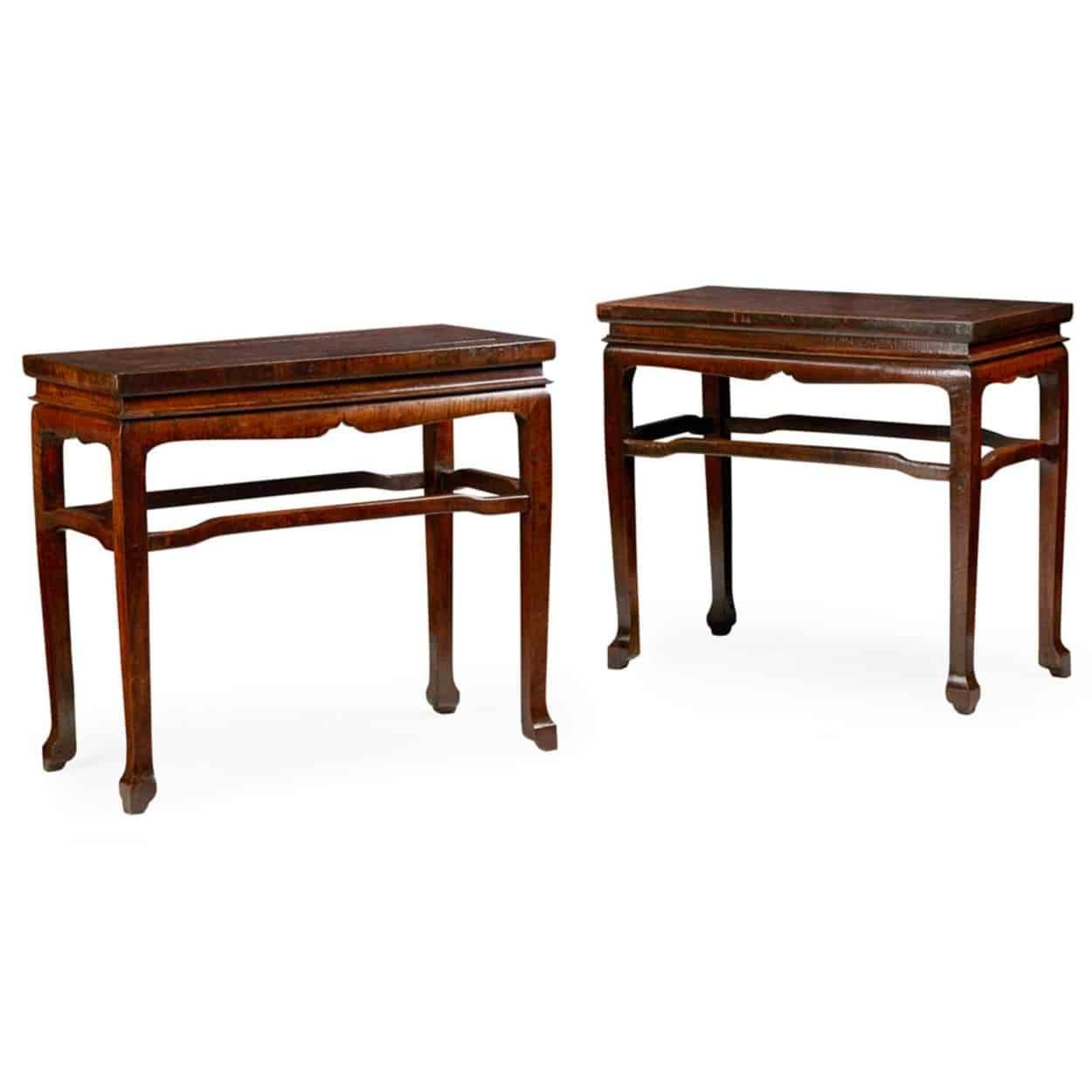 A rare pair of 18th century Chinese longyanmu hardwood side tables, the panel tops above recessed friezes and shaped aprons, raised on square straight legs ending in shaped block feet and joined by arched stretchers.

Furniture constructed from