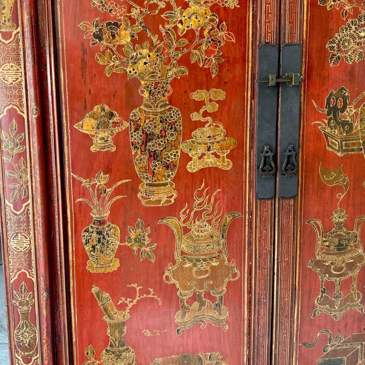 Ein Paar Schränke aus rot lackiertem Ulmenholz, reich verziert und außergewöhnlich gut erhalten.
Die Motive sind mit Blattgold auf Lack ausgeführt - eine klassische chinesische Dekorationstechnik - und zeigen wertvolle Gegenstände wie Blumenvasen,