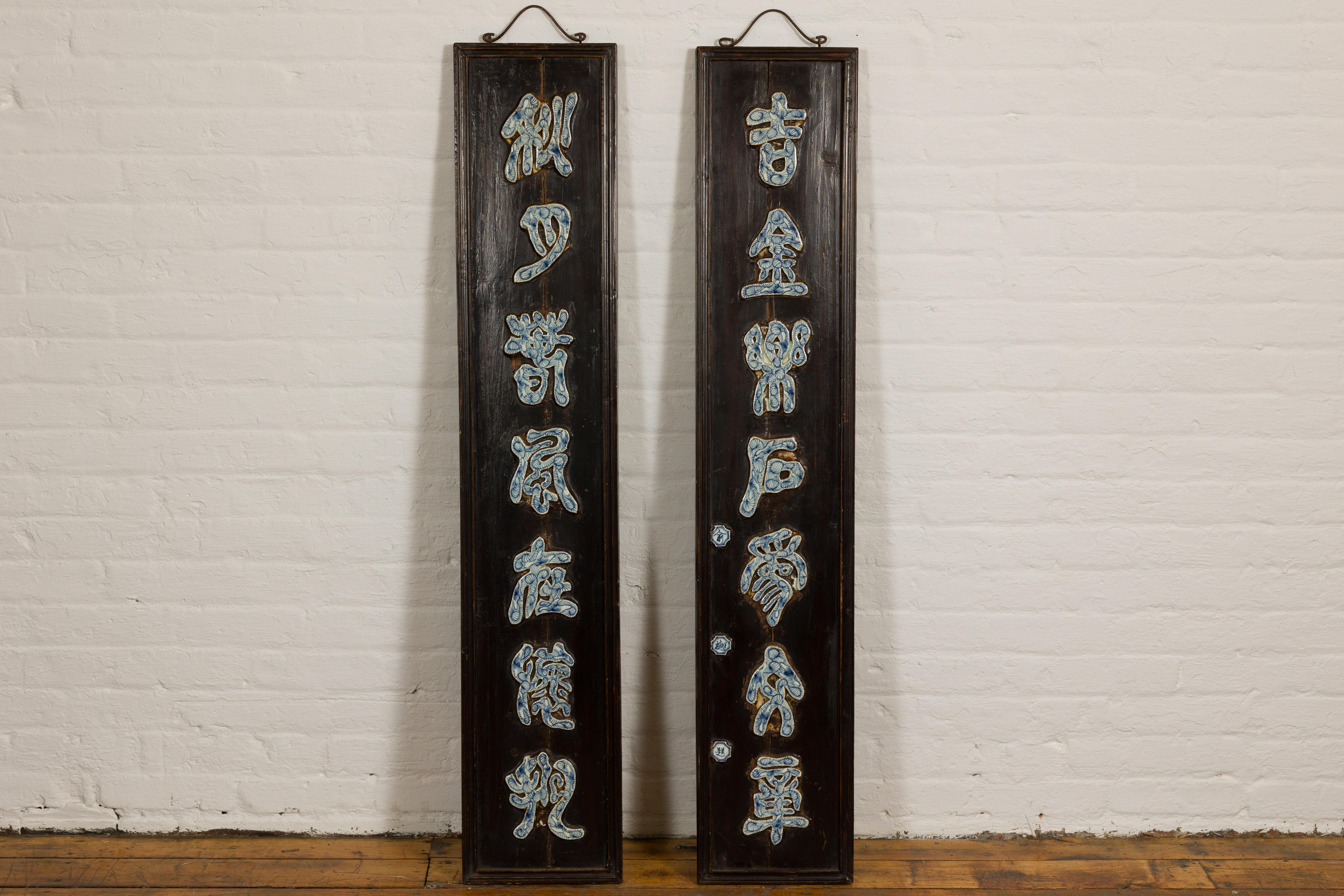 A pair of Chinese Qing Dynasty period shop signs with inlaid blue and white porcelain calligraphy and black/dark brown lacquered ground. Presenting a unique pair of Chinese Qing Dynasty period shop signs, skillfully crafted with an enticing