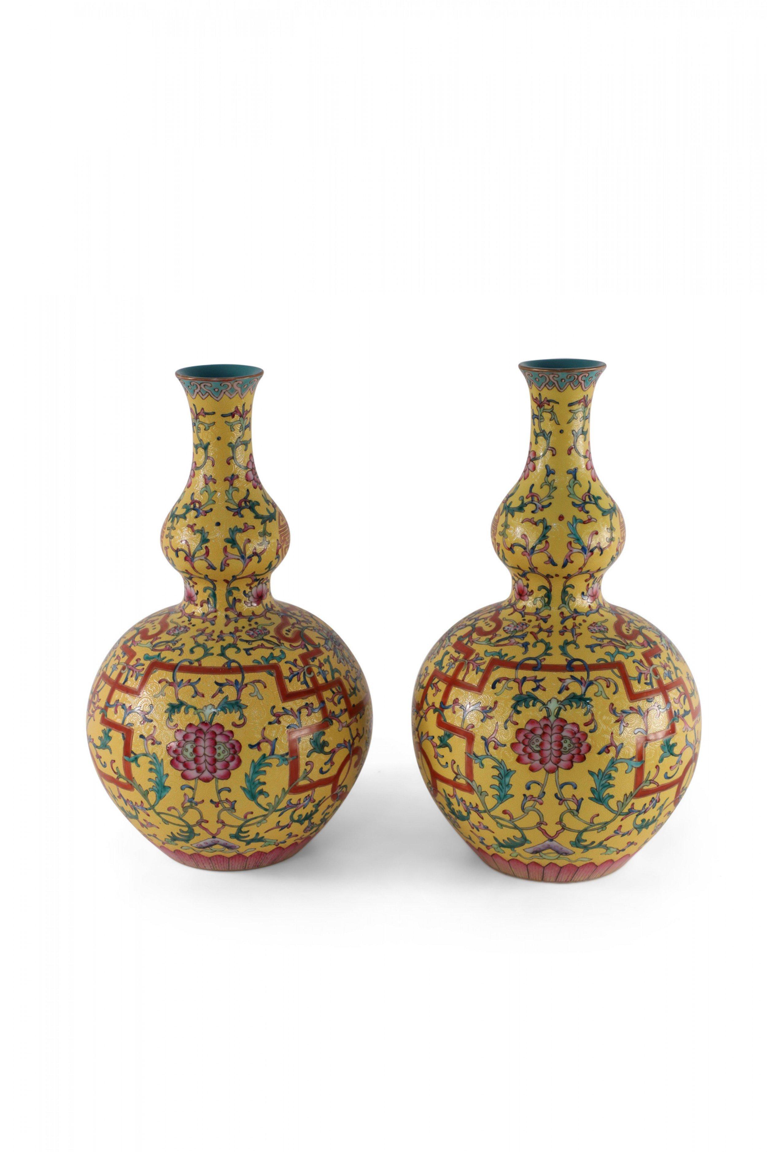 COPPIA di vasi in ceramica smaltata gialla in stile periodo Qianlong della dinastia Qing cinese (inizio del XX secolo) a forma di doppia zucca con fondo inciso e decorato a spirale sotto disegni floreali verdi, rosa e rossi e interni smaltati color