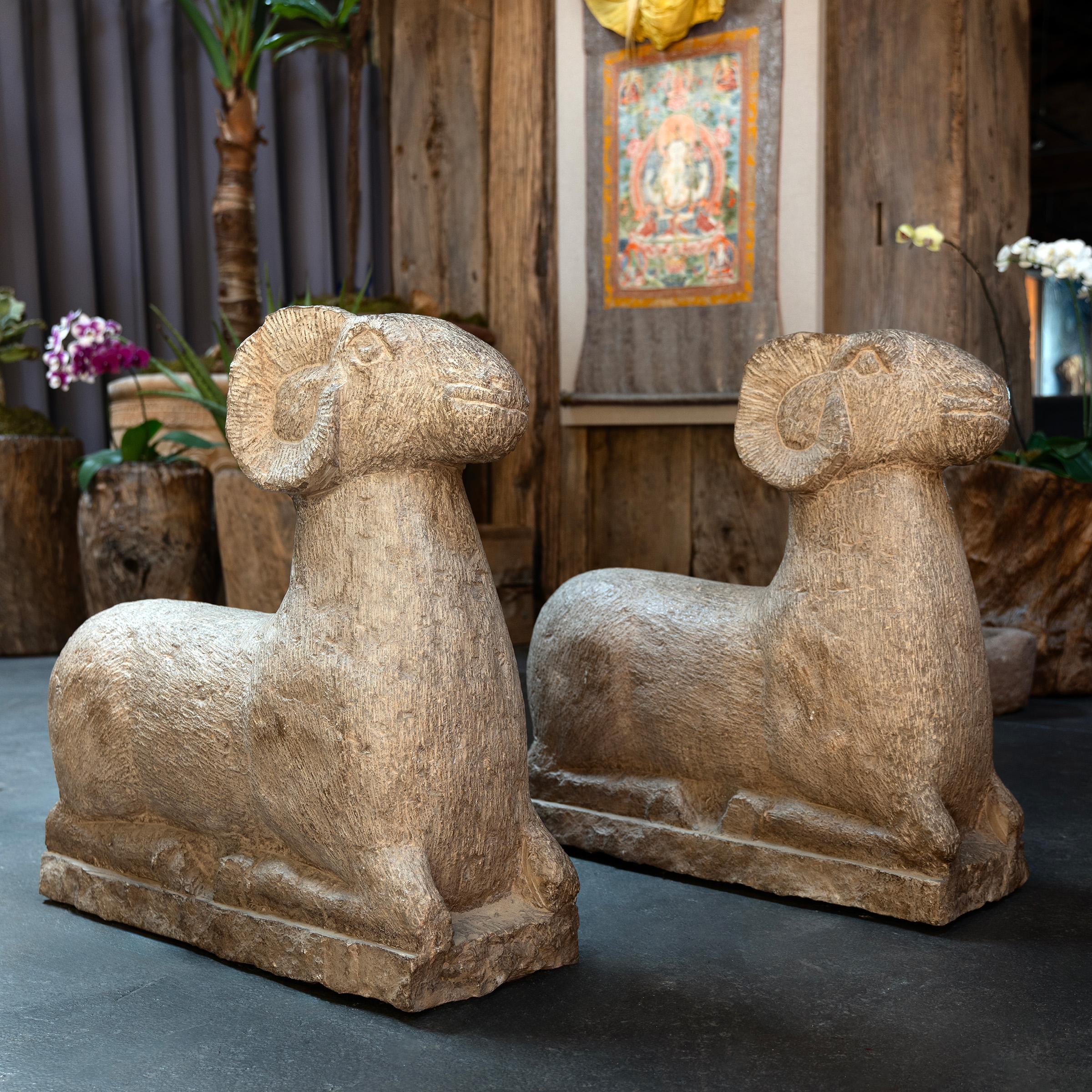 These impressive stone garden statues are hand-carved of solid limestone to the form of two reclining rams. As motifs in Chinese art, rams and sheep represent the breath of light and life, which returns each year when winter thaws and yields to