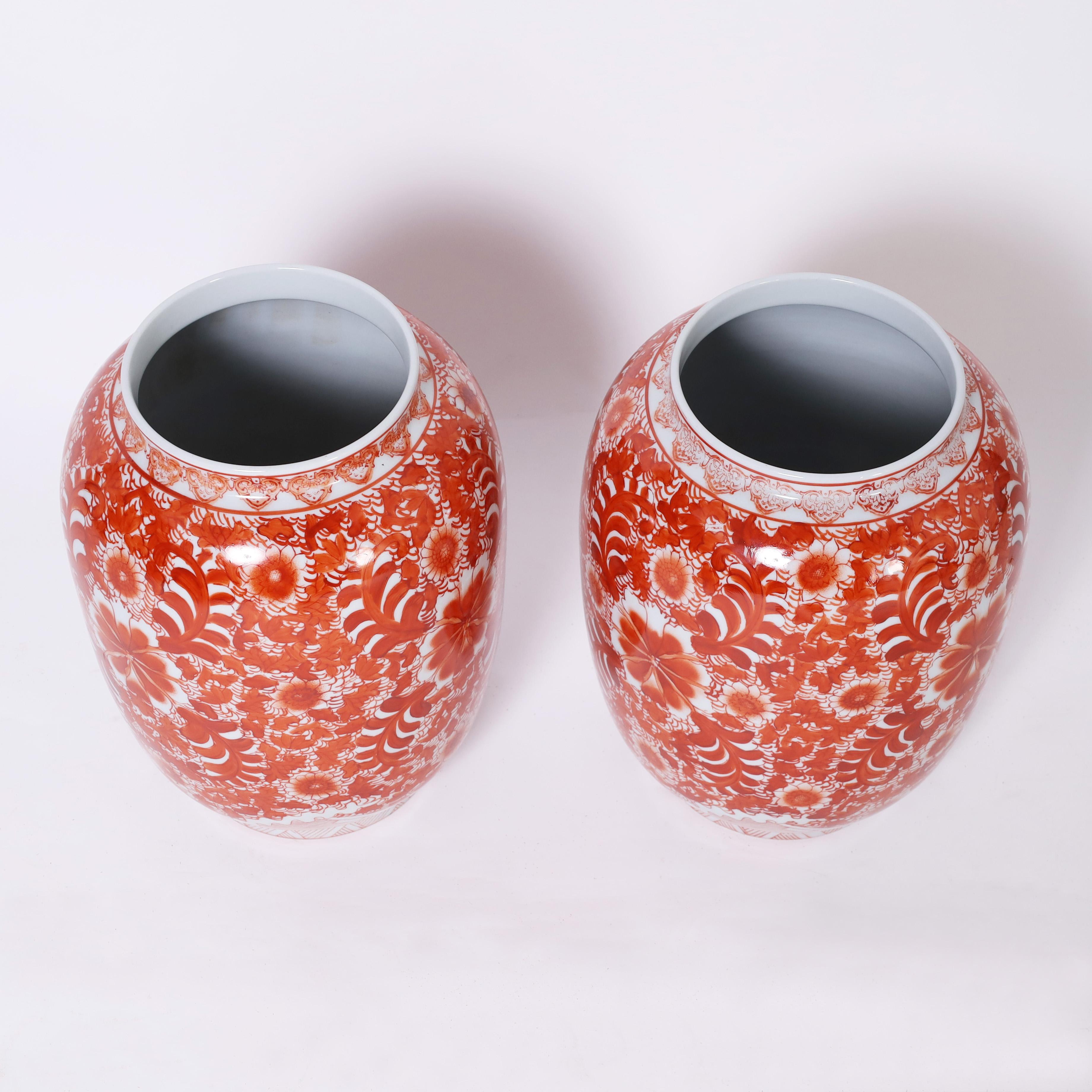 Enchanting pair of Chinese porcelain jars handcrafted in classic form and hand decorated in red and white floral designs.