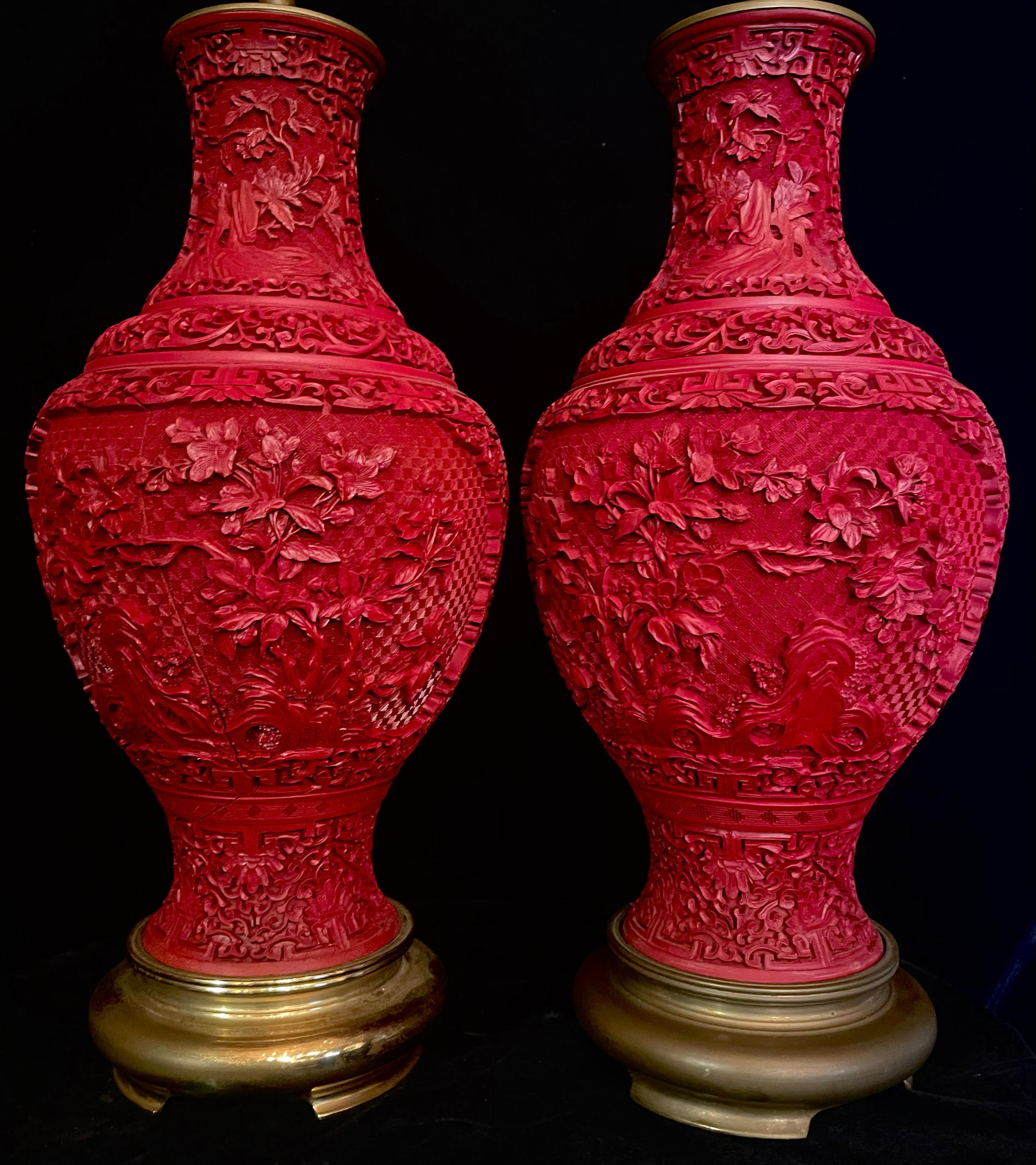 Ein auffälliges und fein gearbeitetes Paar chinesischer Lampen aus rotem Zinnober und vergoldeter Bronze. Jede Leuchte steht auf einem runden Sockel aus vergoldeter Bronze mit gewölbtem Profil und reicher gedämpfter Goldpatina, der einen