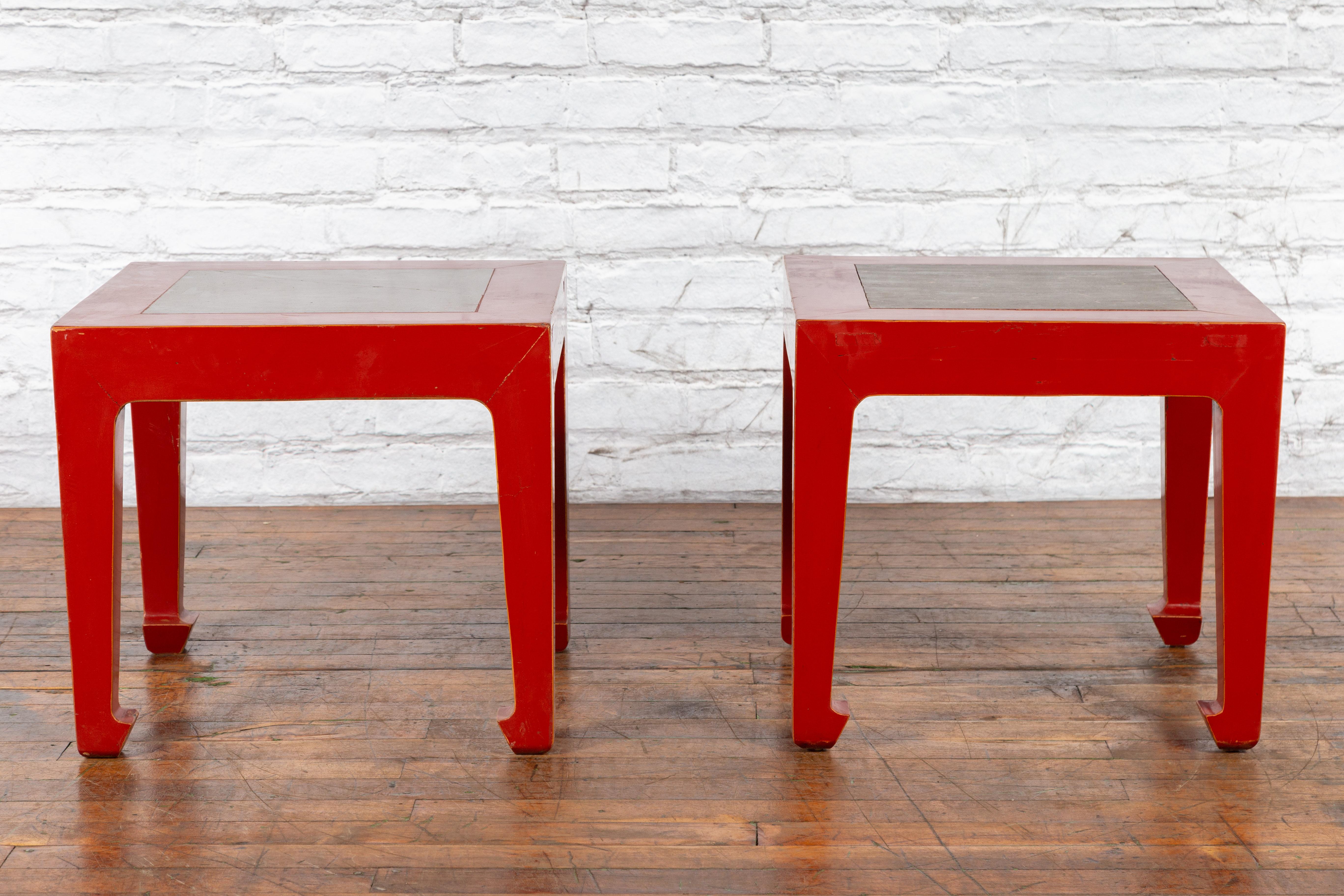 Paire de tables d'appoint chinoises vintage du milieu du 20e siècle, avec  laque rouge, dessus de carreaux de jardin en pierre de la période de la dynastie Qing et pieds en sabot de cheval. Créée en Chine au milieu du siècle dernier, cette paire de