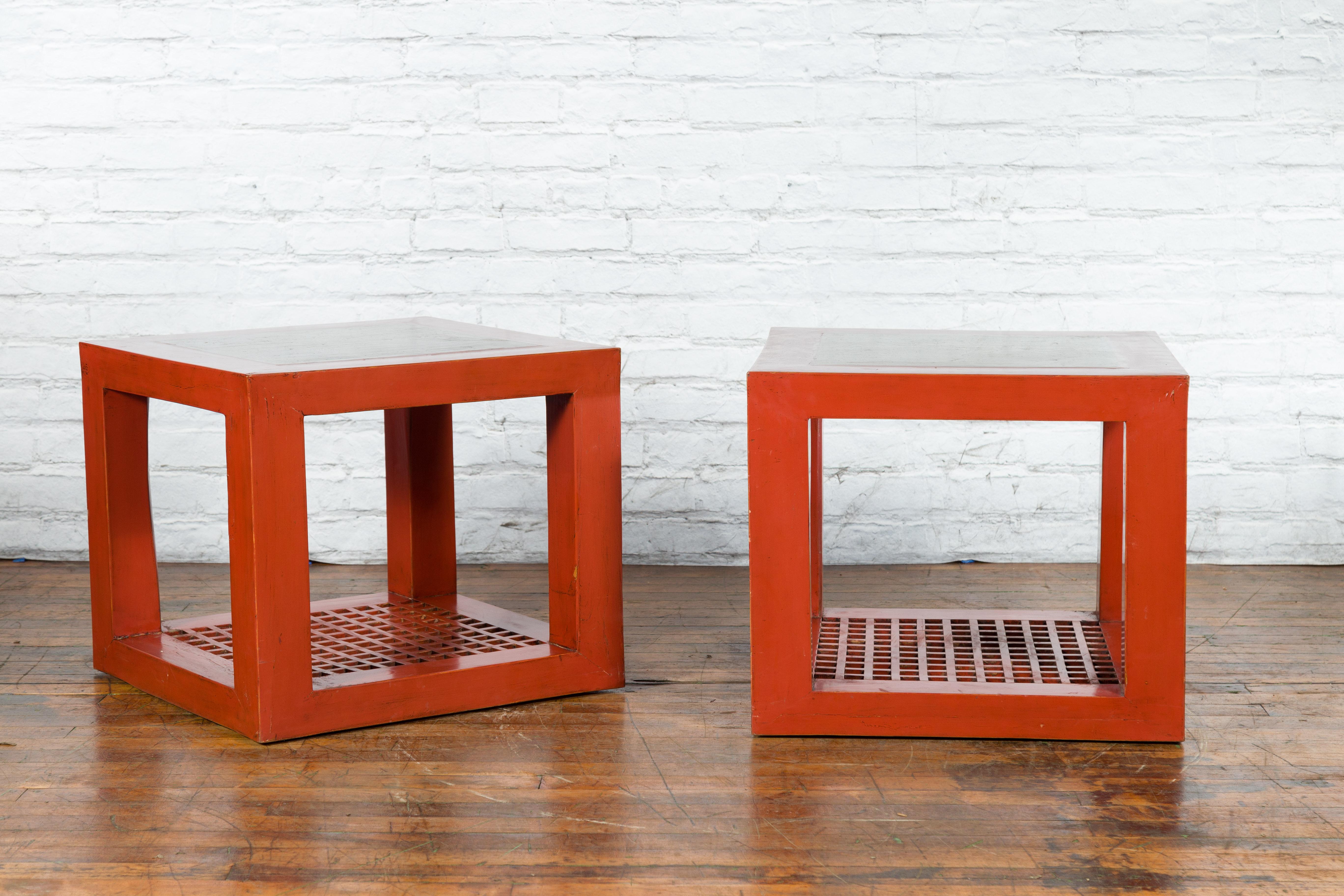 A pair of Chinese elmwood cube shaped side tables from the late 20th century made with antique red lacquered elmwood and possibly Ming Dynasty period marble inset tops coming from a temple courtyard. Created in China during the third quarter of the