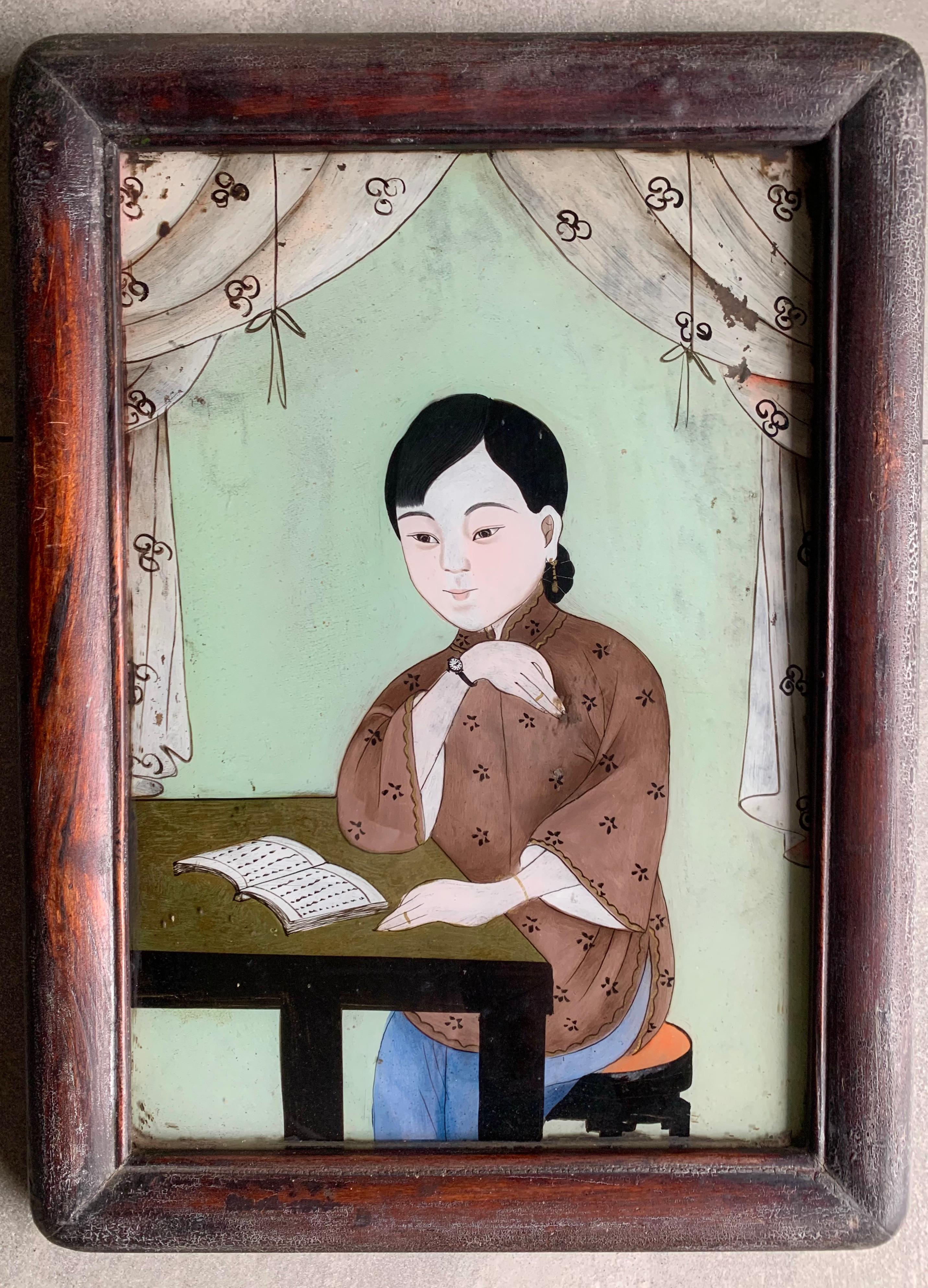 This pair of Chinese portraits depicting young women were painted using a reverse glass painting technique. Painting in reverse on the opposite side of a piece of glass meant the painter had to work in reverse. They still possess much of their