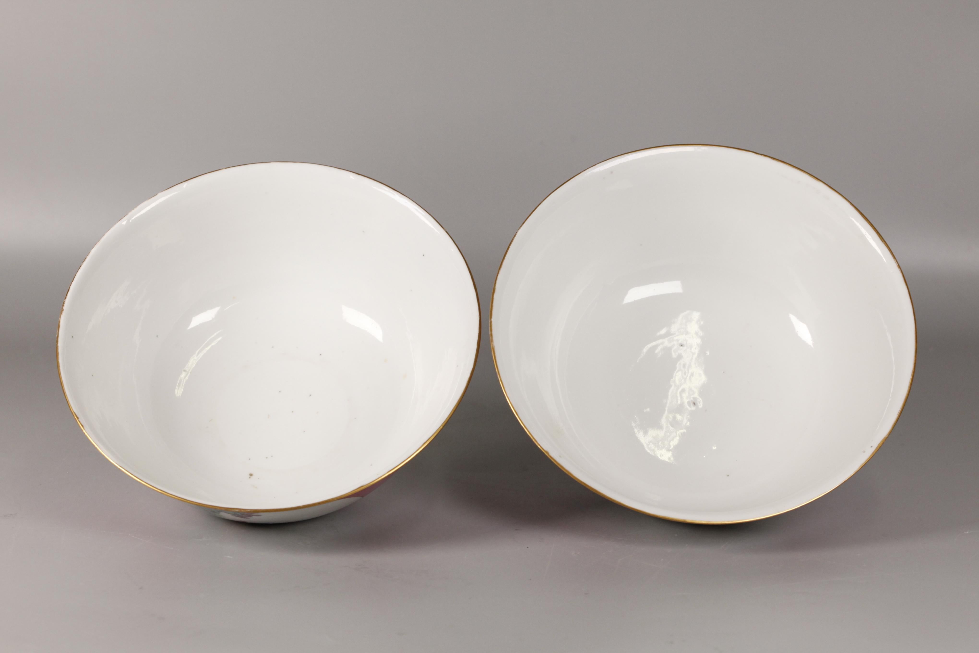 each ruby red porcelain bowl decorated with circular panels depicting landscape scenes