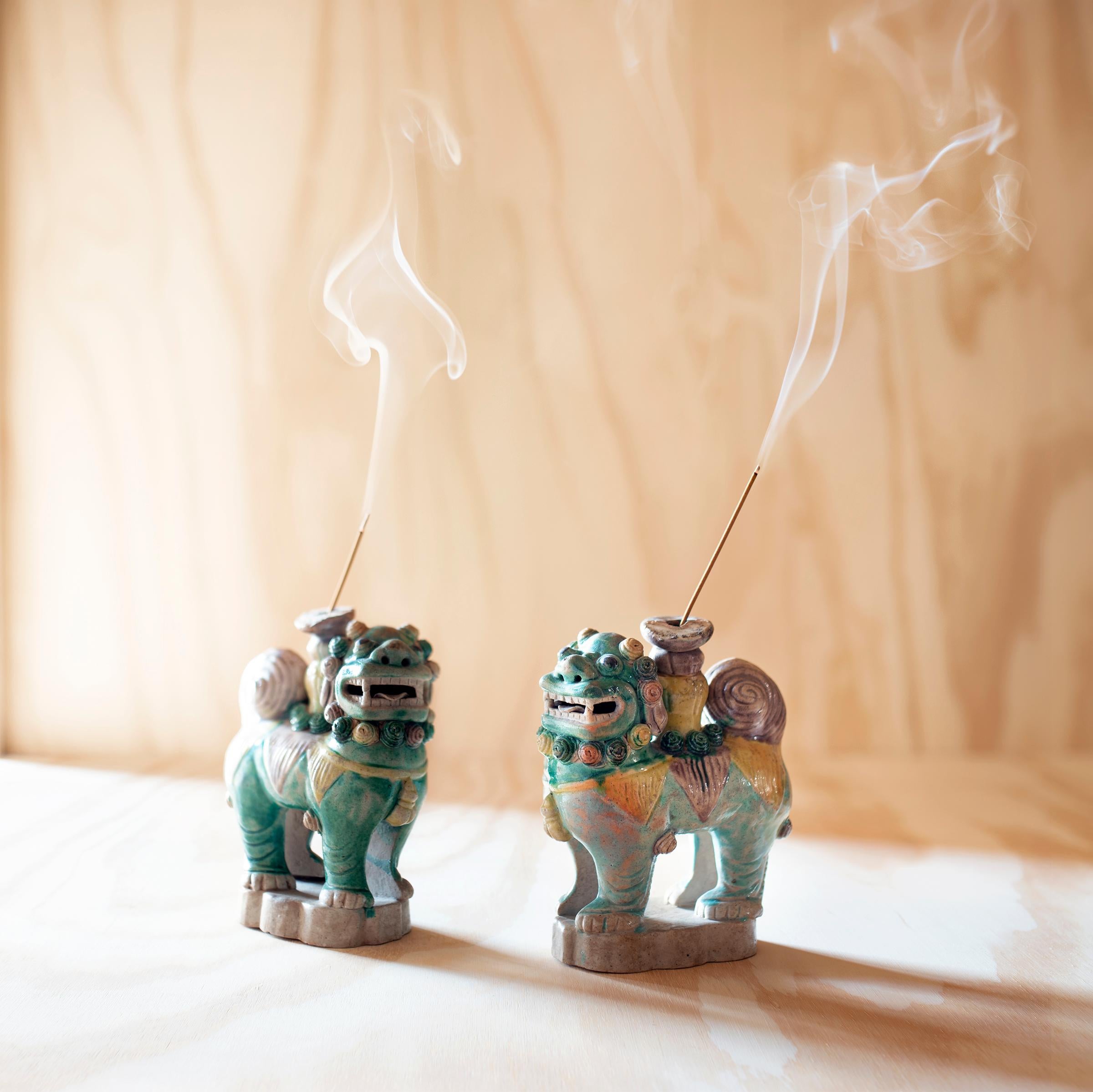 These petite ceramic fu dog figurines likely once stood upon a home altar as incense burners to accompany ritual ancestor worship. Also known as shizi, pairs of fu dog lions are believed to be benevolent protectors and are traditionally placed at