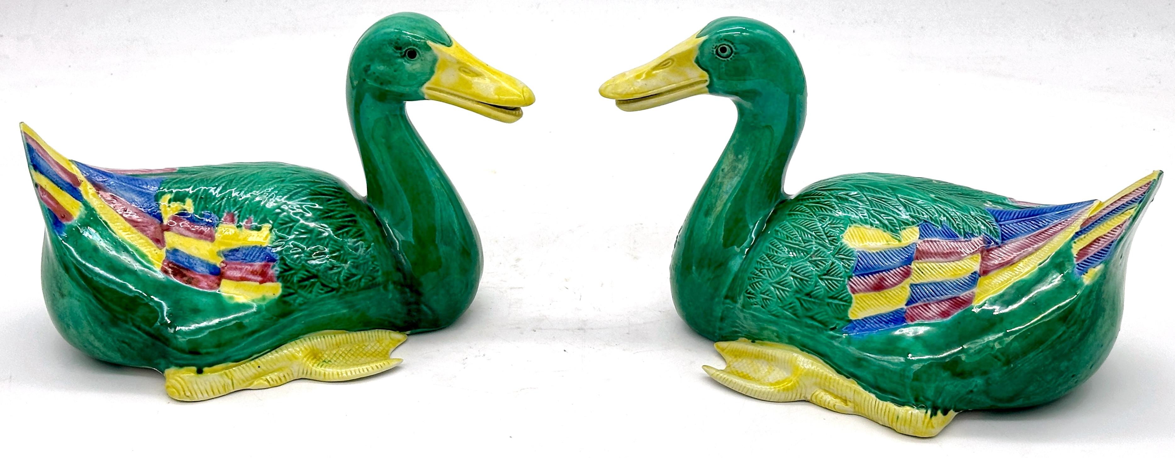 Pair of Chinese Sancai Glazed Seated Ducks—20th Century 

Dimensions (Each Duck): 9” W x 6” H x 5” D

This stunning pair of Chinese sancai-glazed ceramic ducks, made in the 20th century, showcases vibrant green, yellow, blue, and aubergine hues in