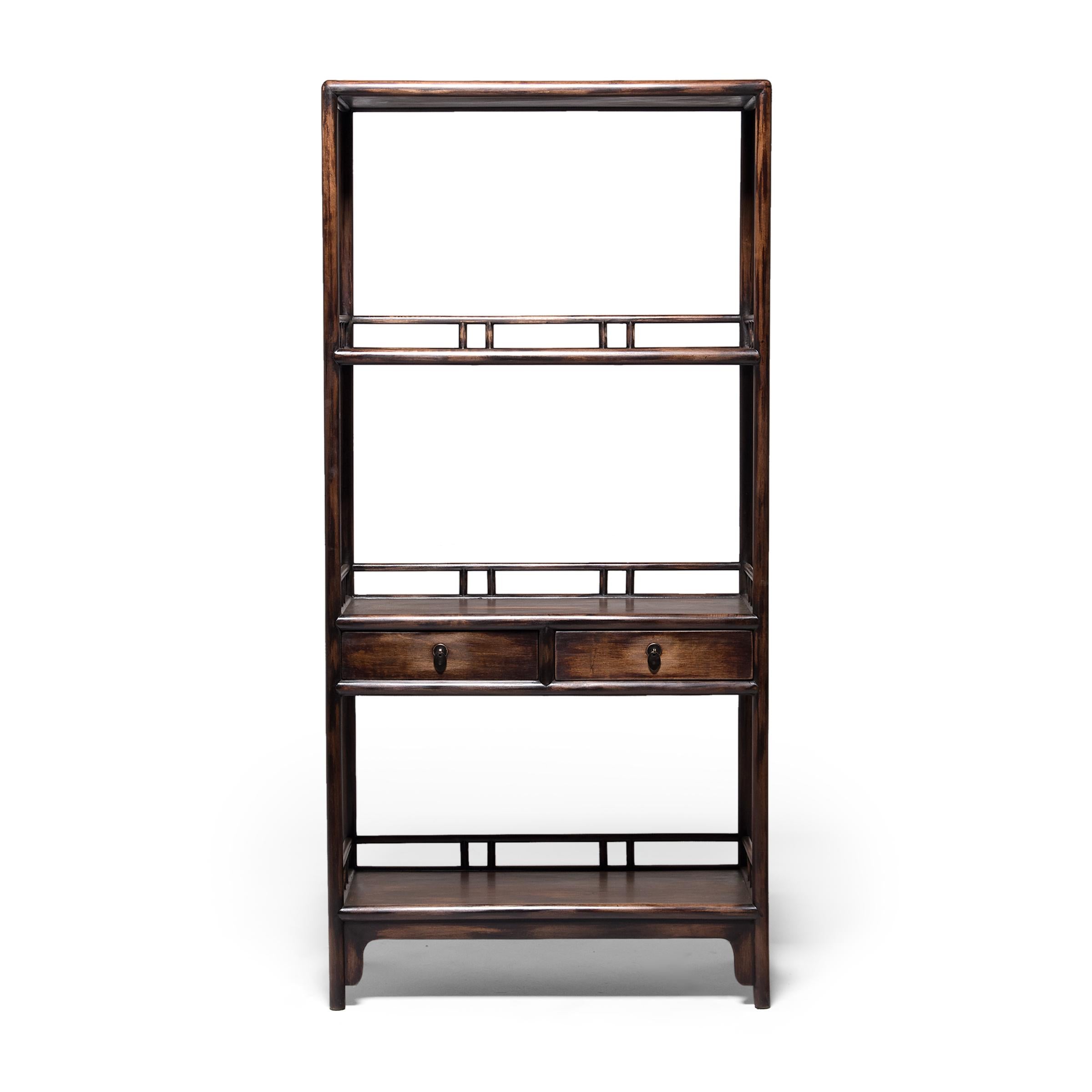 Dated to the early 20th century, this pair of two-drawer collector's shelves is seamlessly constructed with clean lines and open sides. Rounded edges soften the angular frame and reference the bent bamboo furniture of earlier dynasties. Once the