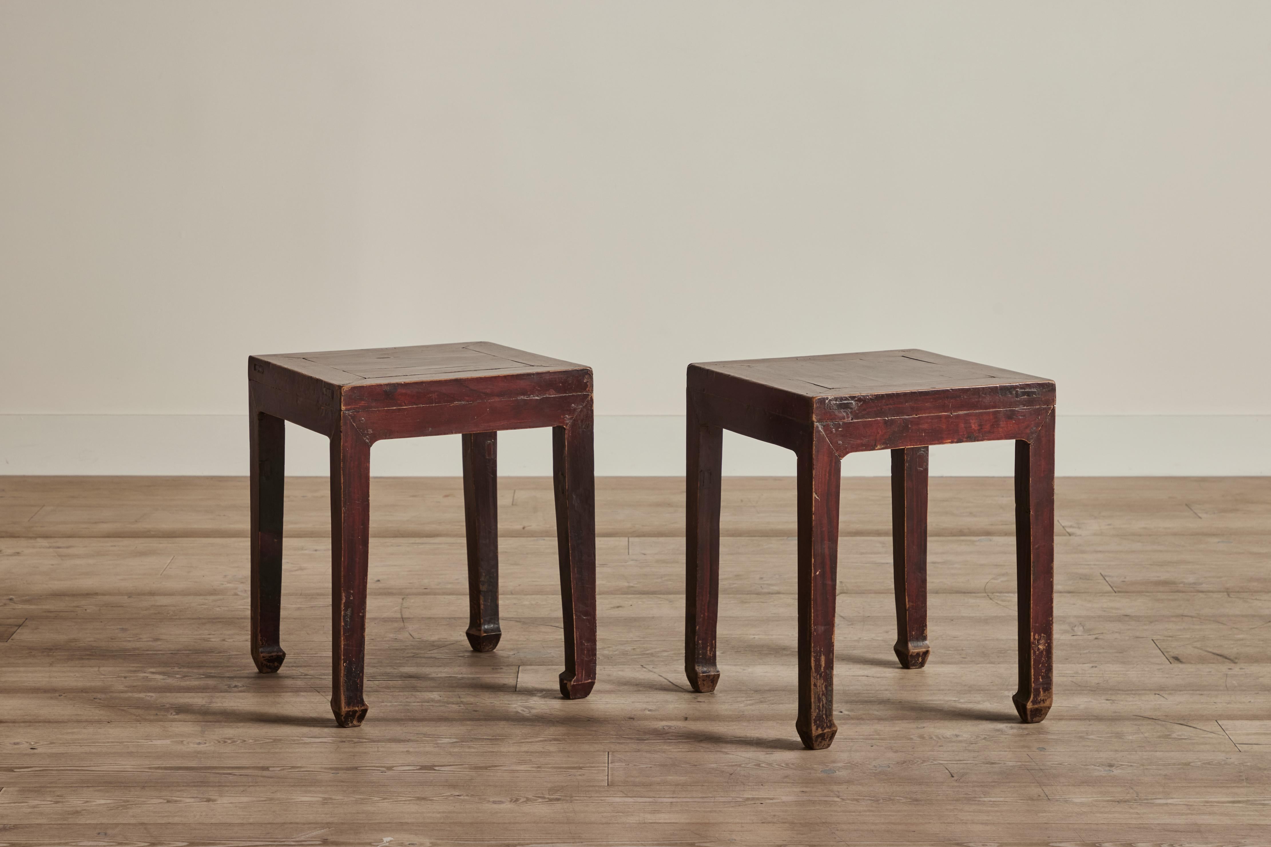 Paire de tables d'appoint en bois peint de Chine du début du 20e siècle. Ces tables sont peintes dans une finition cramoisie profonde. Usure du bois et de la finition. 
