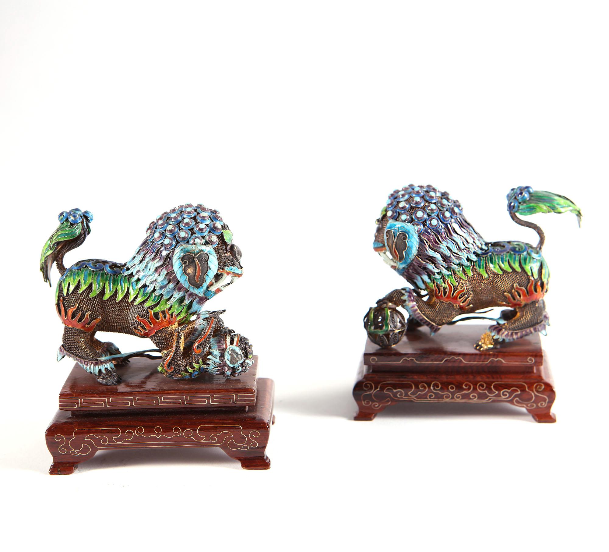 Pair of Chinese enamel Dogs of Fo or Guardian Lions with silver-gilt mesh bodies hung with panels of blue, green and red enamel.
China, 20th century

Measures: Height on stands 9.5cm - 3 3/4in
Length 9cm - 3 1/2in
Depth 6cm - 2 1/4in.