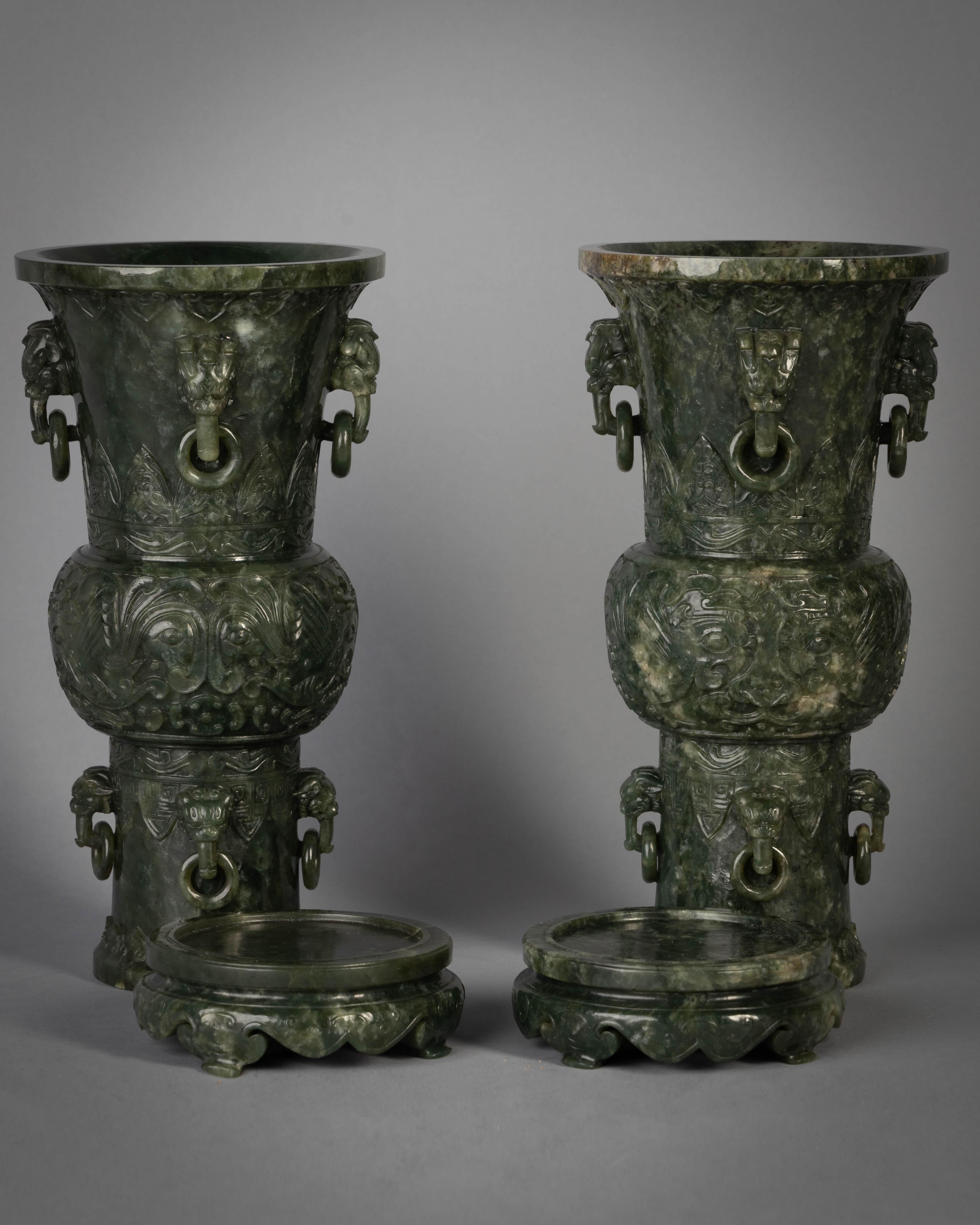 Each of Archaistic gu beaker form, with the globular central bulb carved with confronting phoenixes forming Archaistic taotie masks, with further borders of lappets and ruyi-heads at the pedestal foot and trumpet neck, further set with two registers