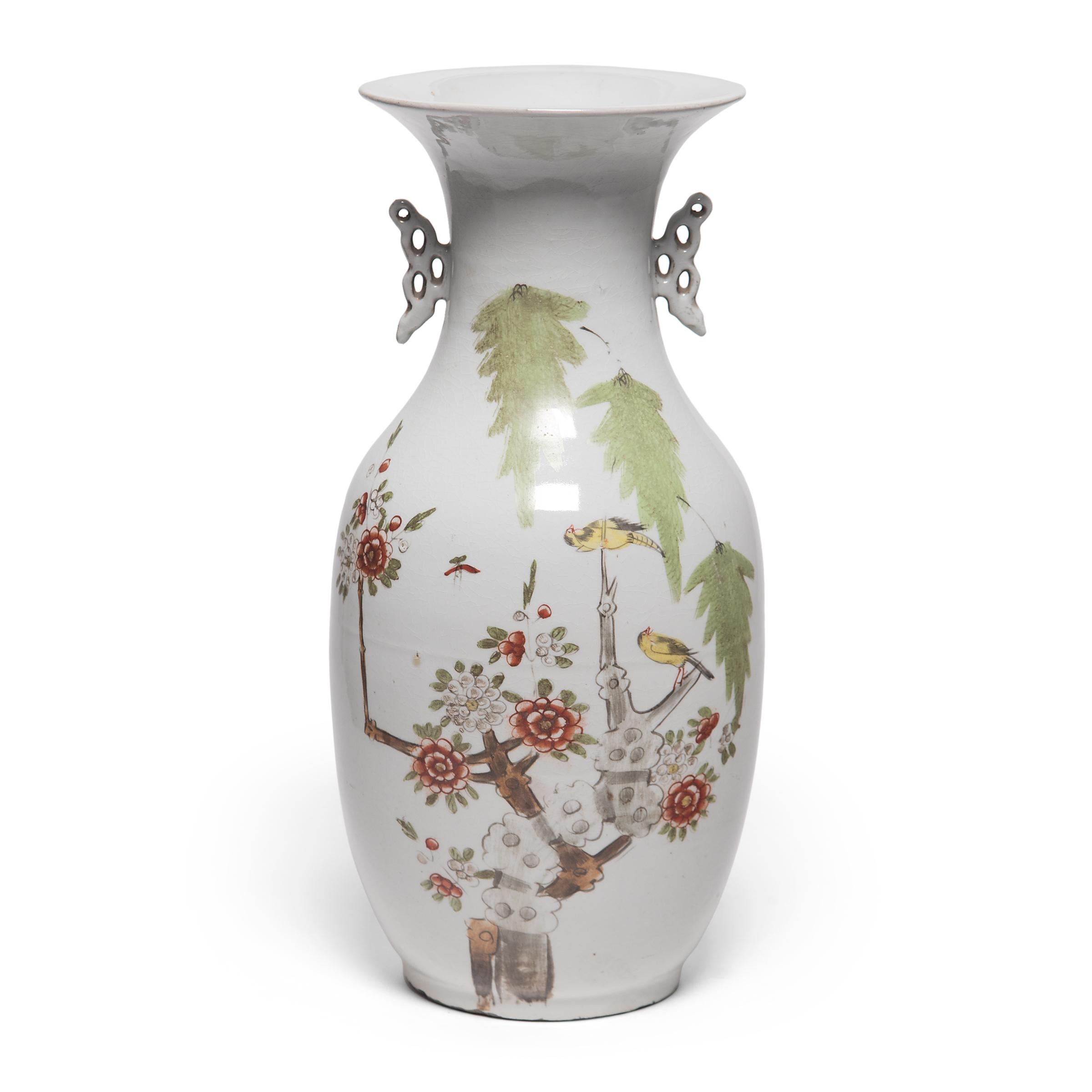 Sculpted in a traditional Chinese phoenix tail vase form, these elegant early 20th century vases are adorned with scenes of magpies flitting between branches of cherry blossoms. Regarded as a bird of good omen, magpies bring joy and good fortune to