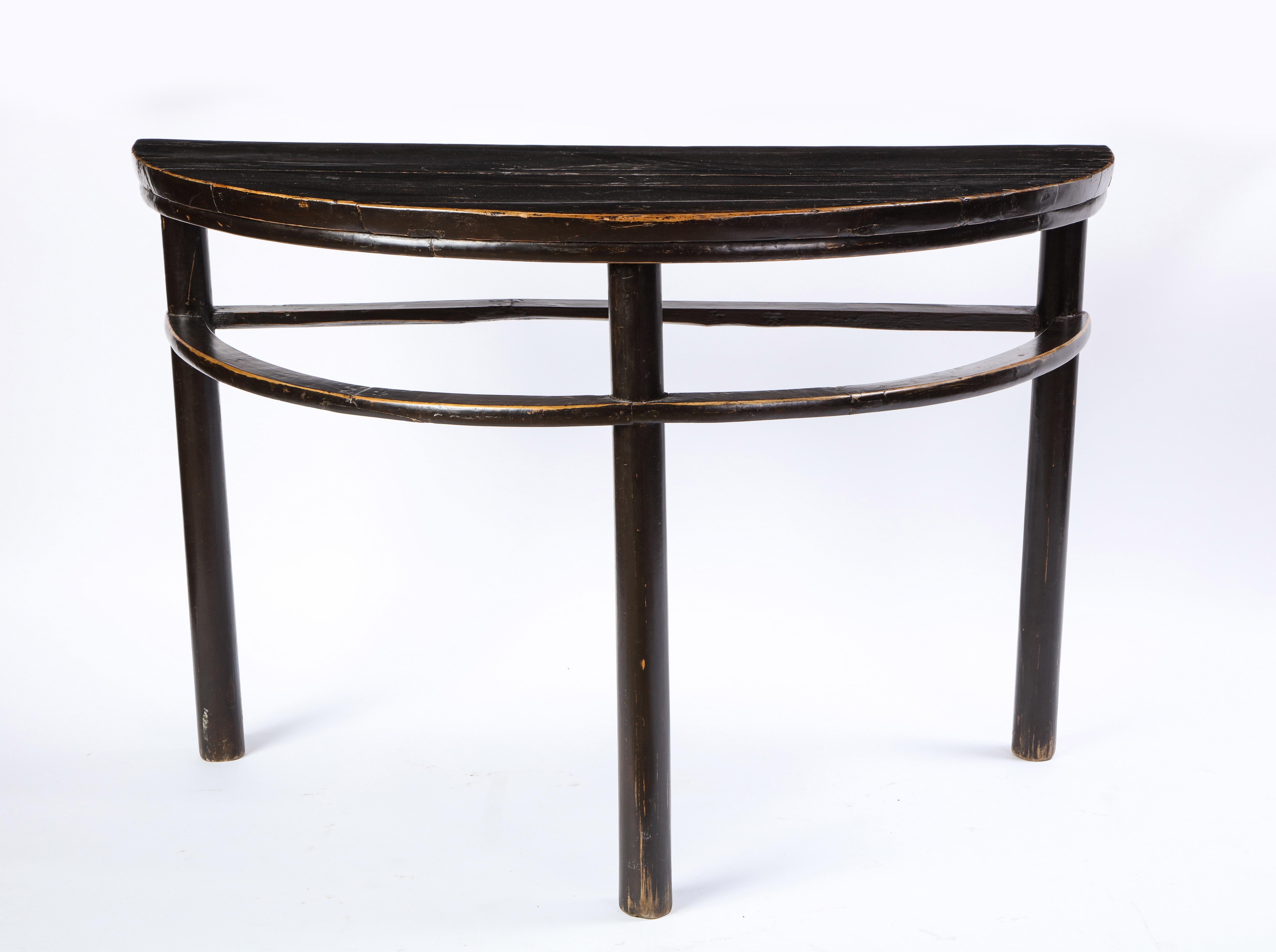 A pair of Chinese stained soft wood demilune side tables, 20th century. Demilune, French for 'half-moon,' tables often appear flanking a fireplace or in an entryway, where the flat back allows for the tables to sit flush on the wall while the curved