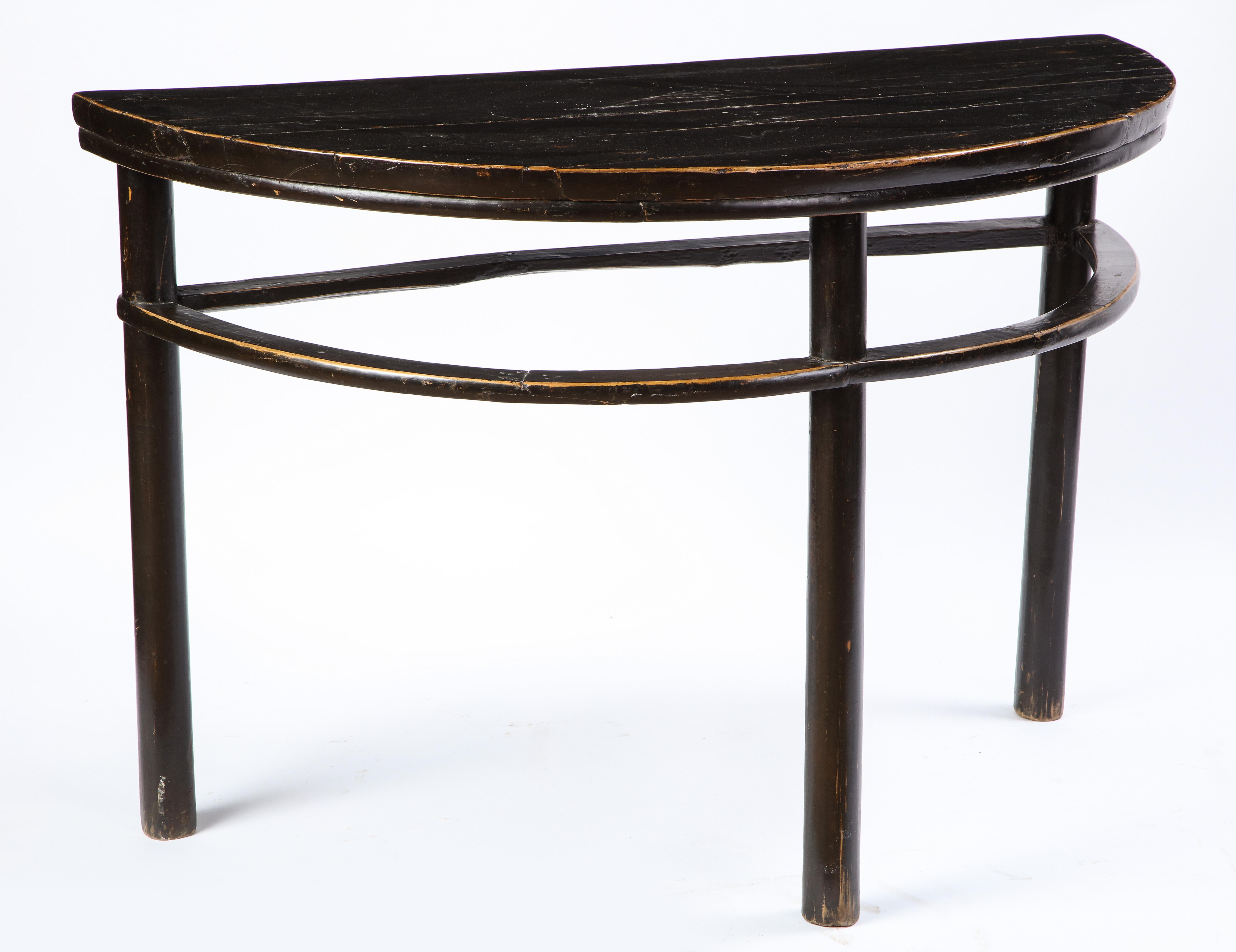 A pair of Chinese stained soft wood demilune side tables, 20th century. Demilune, French for 'half-moon,' tables often appear flanking a fireplace or in an entryway, where the flat back allows for the tables to sit flush on the wall while the curved