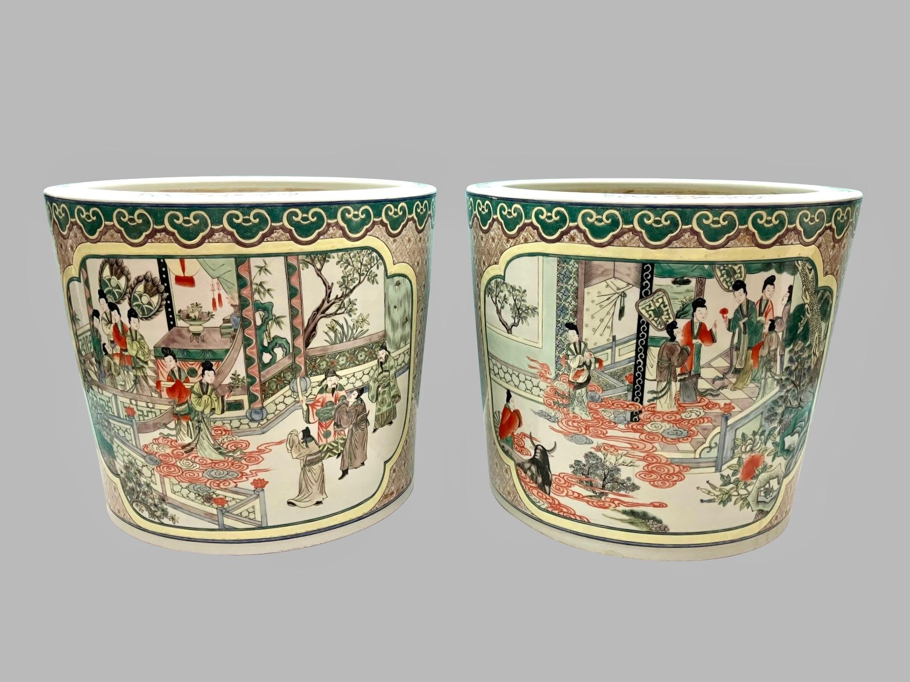 A pretty pair of Chinese export planters or fish bowls in the famille verte palette depicting robed men and women in a fantastic garden setting with animals, plants, flowers, fans and screens, all in the famille verte taste with additional colors of