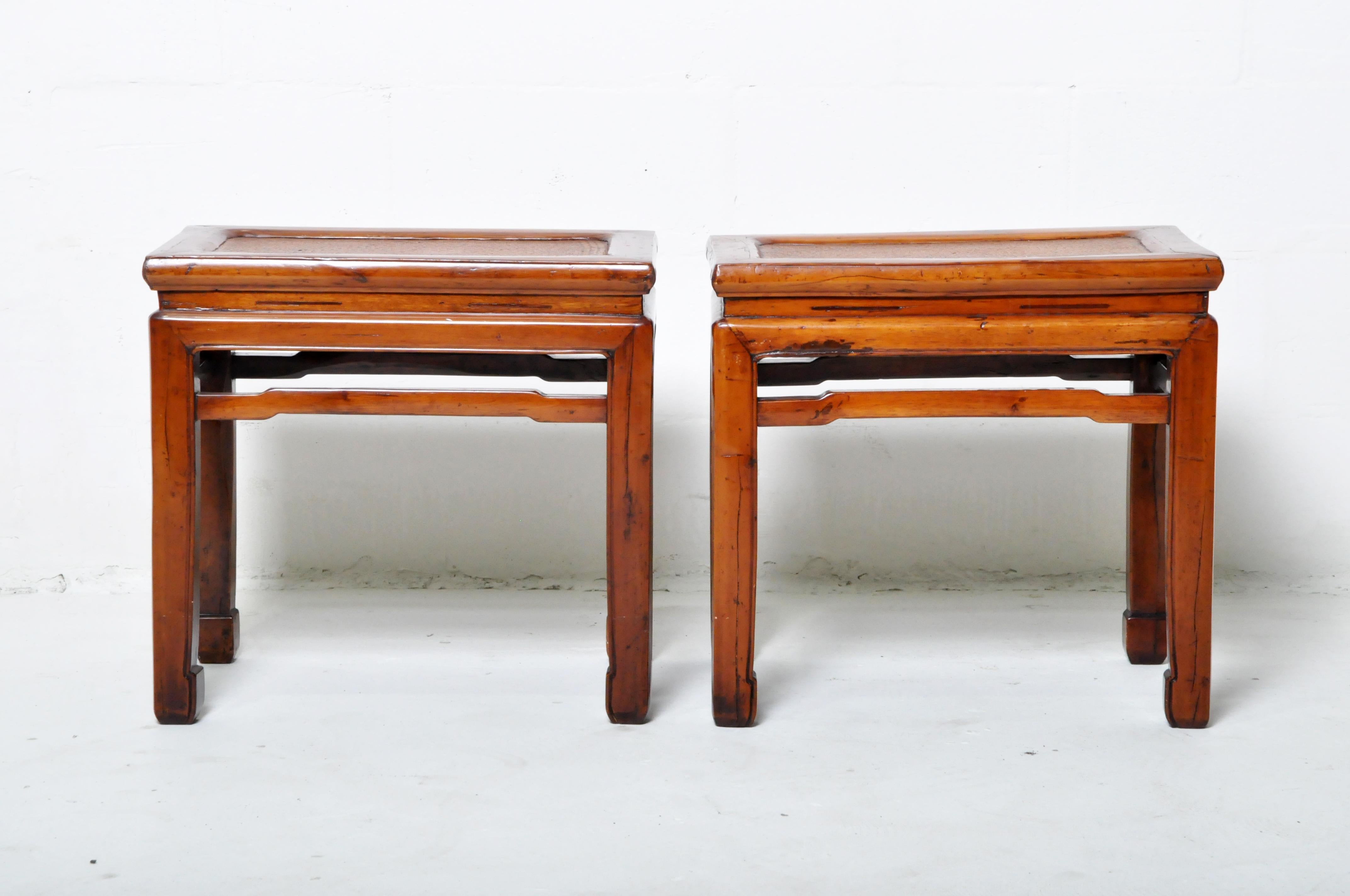These classic Chinese stools feature mortise-and-tenon joinery and woven cane tops. They are made from sturdy and lightweight Cypress wood, carefully selected to be clear of knots. The original lacquer (likely oxblood) has worn away and been
