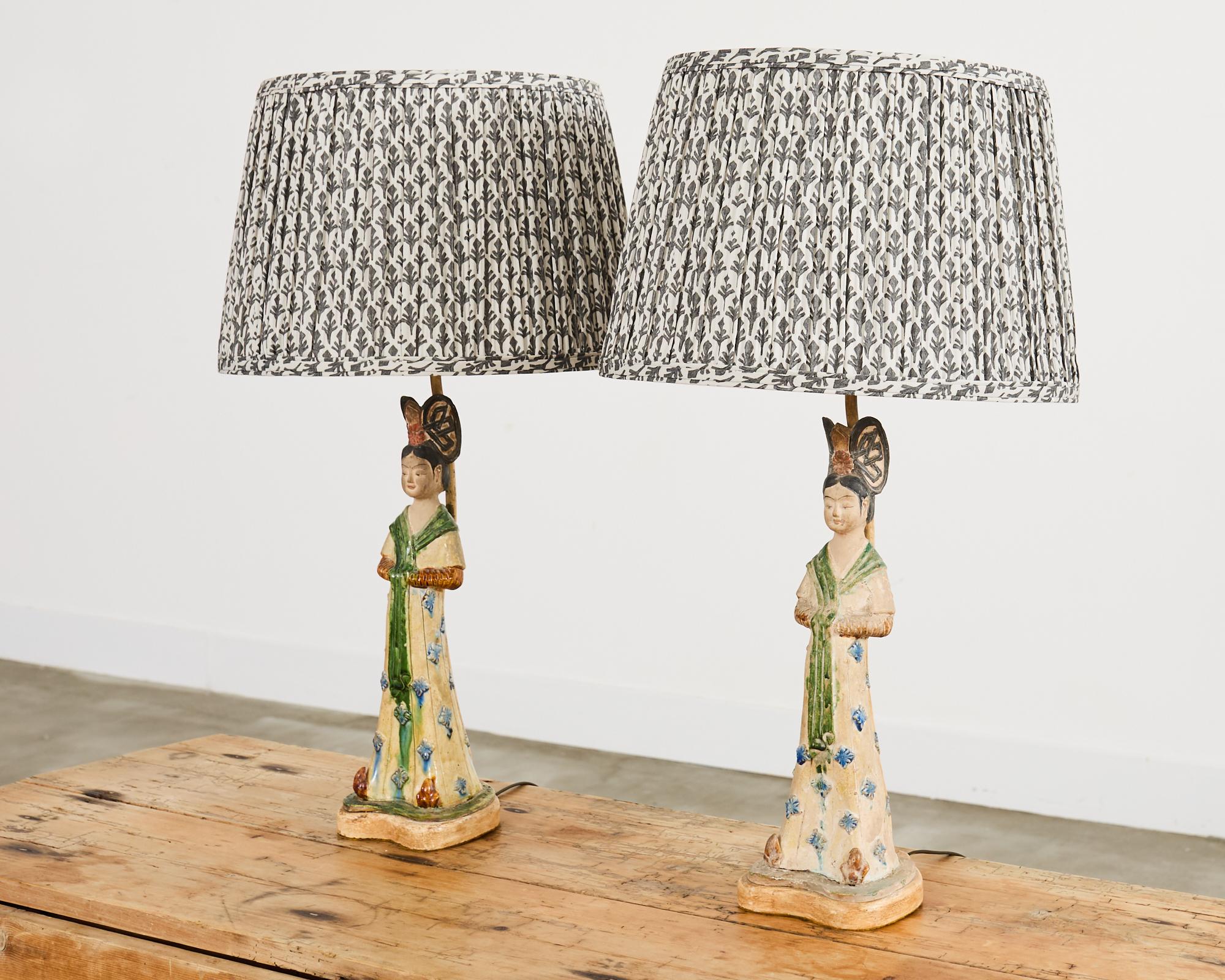 Encantadora pareja de lámparas de sobremesa de cerámica china de exportación con figuras de damas de la corte imperial. Las figuras miden 10 cm de ancho y de fondo por 14 cm de alto. Están montadas sobre zócalos de madera y rematadas con herrajes de