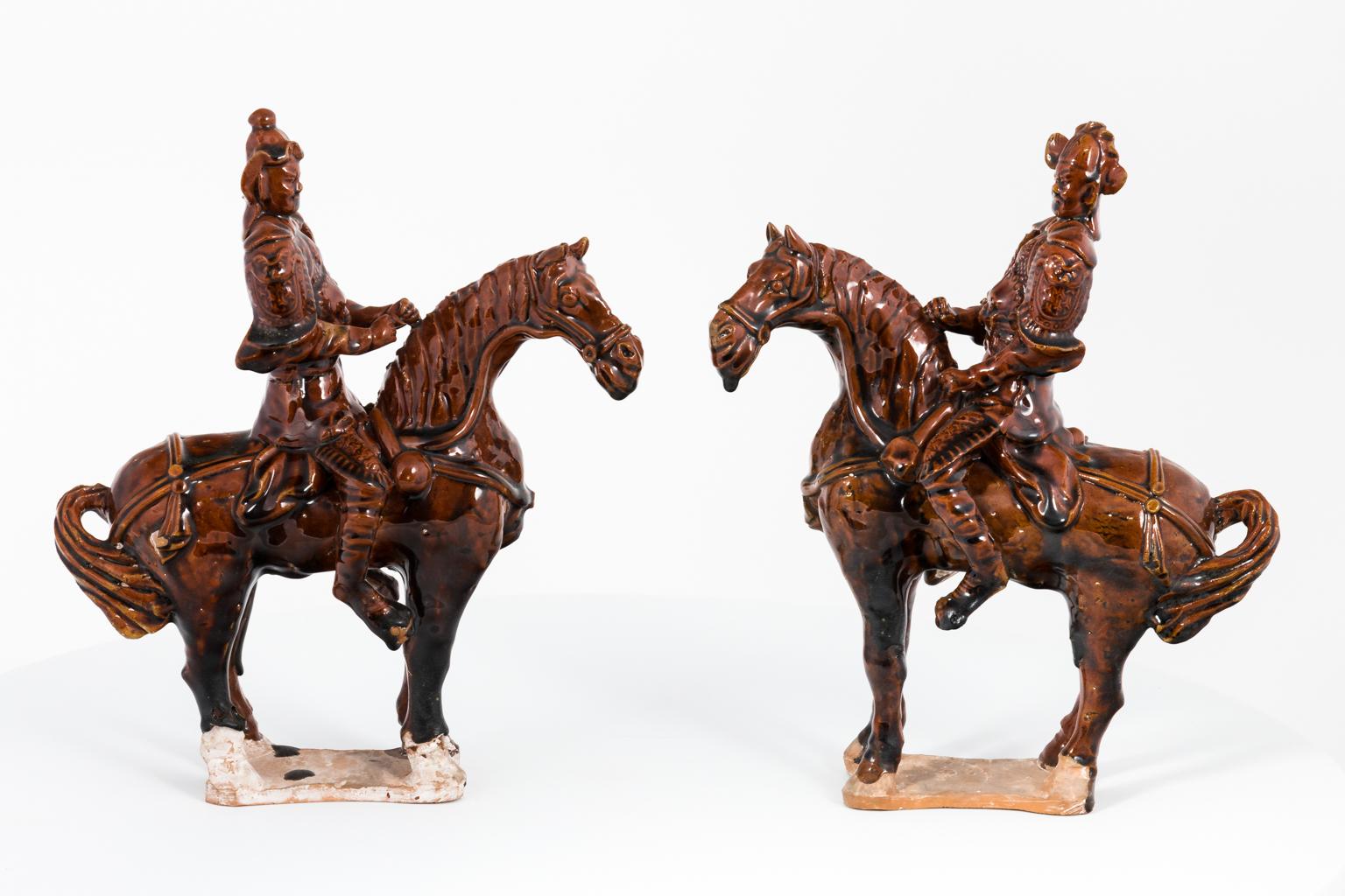 Pair of Tang style mantle figurines depicting two warriors riding horses, circa 1930s. The figurines measure 9.00 inches height by 8.00 inches wide.
